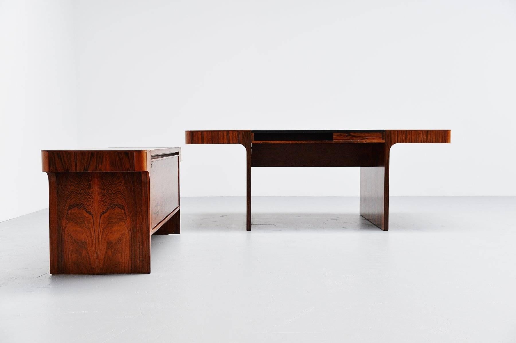 Extraordinary desk set in rosewood, Denmark, 1965. This very nicely shaped desk set has a conference desk and a similar shaped office cabinet with folding door. The desk can be used both sides, there are drawers on both sides and the working top is