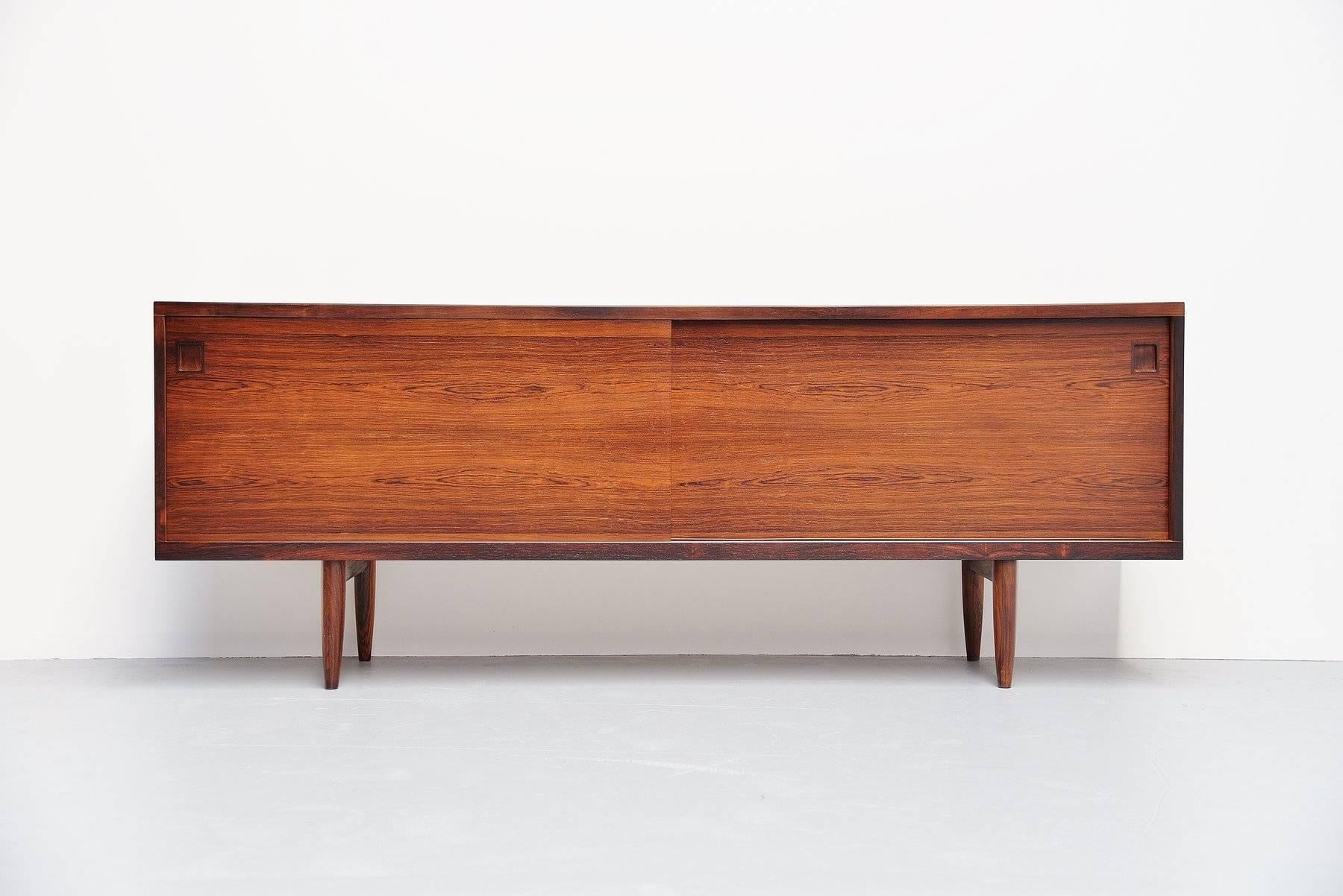 Superb quality sideboard designed by Niels Otto Moller produced by J.L. Møller Møbelfabrik, Denmark, 1960. This high quality made sideboard is made of rosewood, partly solid partly veneer. The sideboard has two sliding doors and shelves behind, even