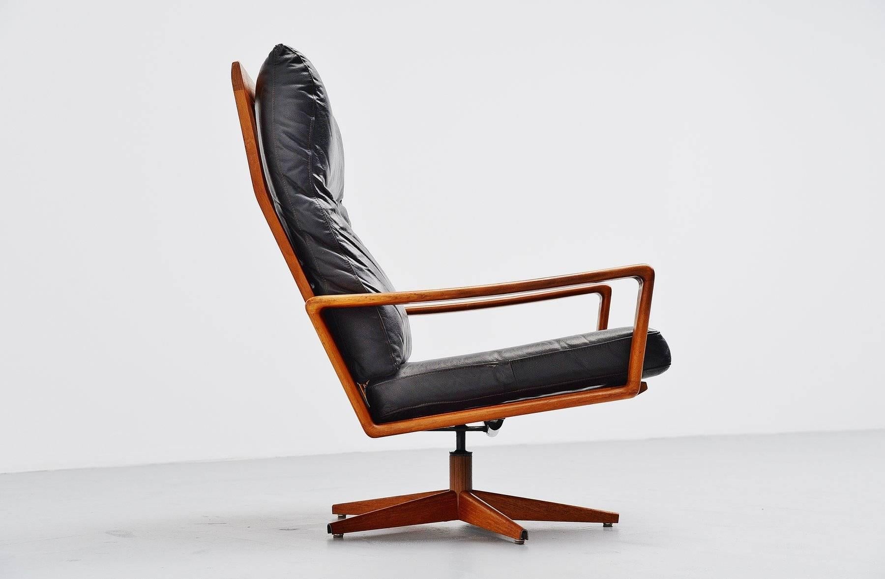 Comfortable swivel lounge chair designed by Arne Wahl Iversen for Komfort, Denmark, 1960. This chair has a solid teak wooden frame with a metal base covered with teak veneer and a black leather seat. It swivels for comfort seating. The chair is in