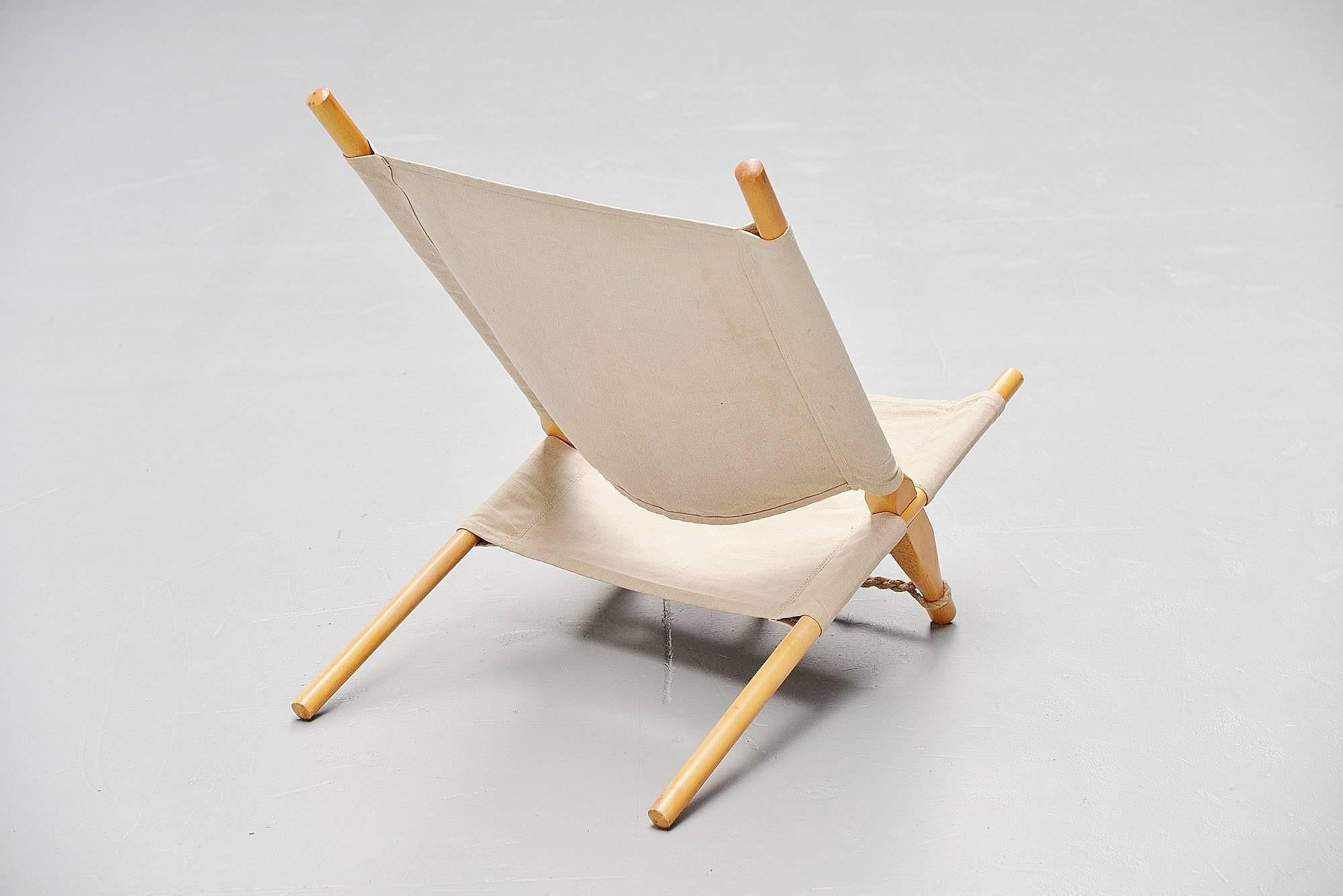 Very nice dynamic low lounge chair designed by Ole Gjerlov Knudsen, manufactured by Cado, Denmark, 1958. The chair has a birch wooden frame existing in four parts sliding in each other to change the angle if wanted. The canvas seat and the rope