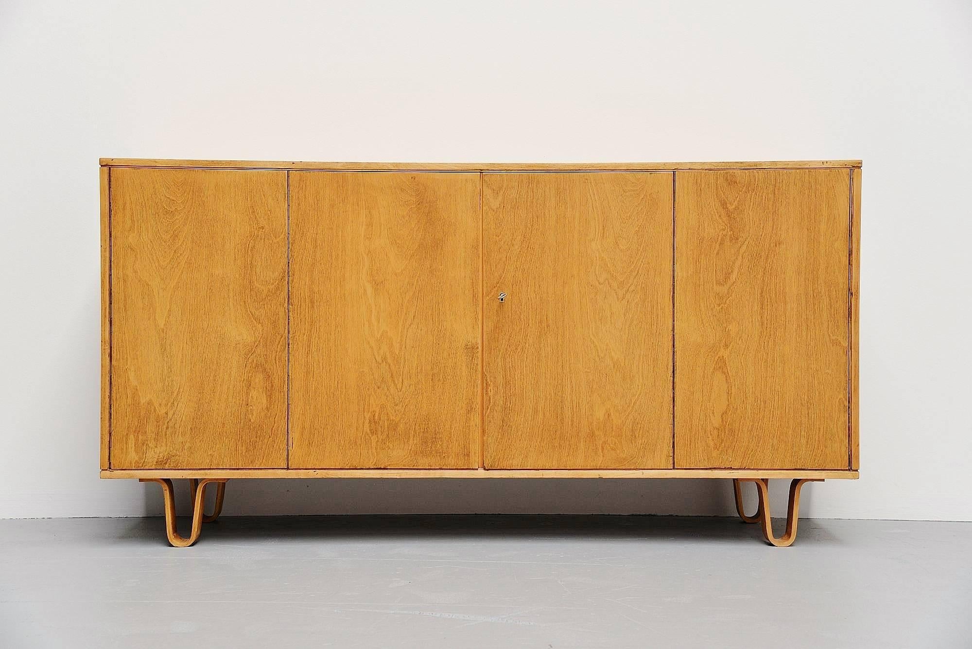 Modernist sideboard model DB02 designed by Cees Braakman, manufactured by Pastoe UMS, Holland, 1952. This sideboard has a double folding door with three shelves and four drawers behind. This sideboard is from the famous birch series by Cees Braakman