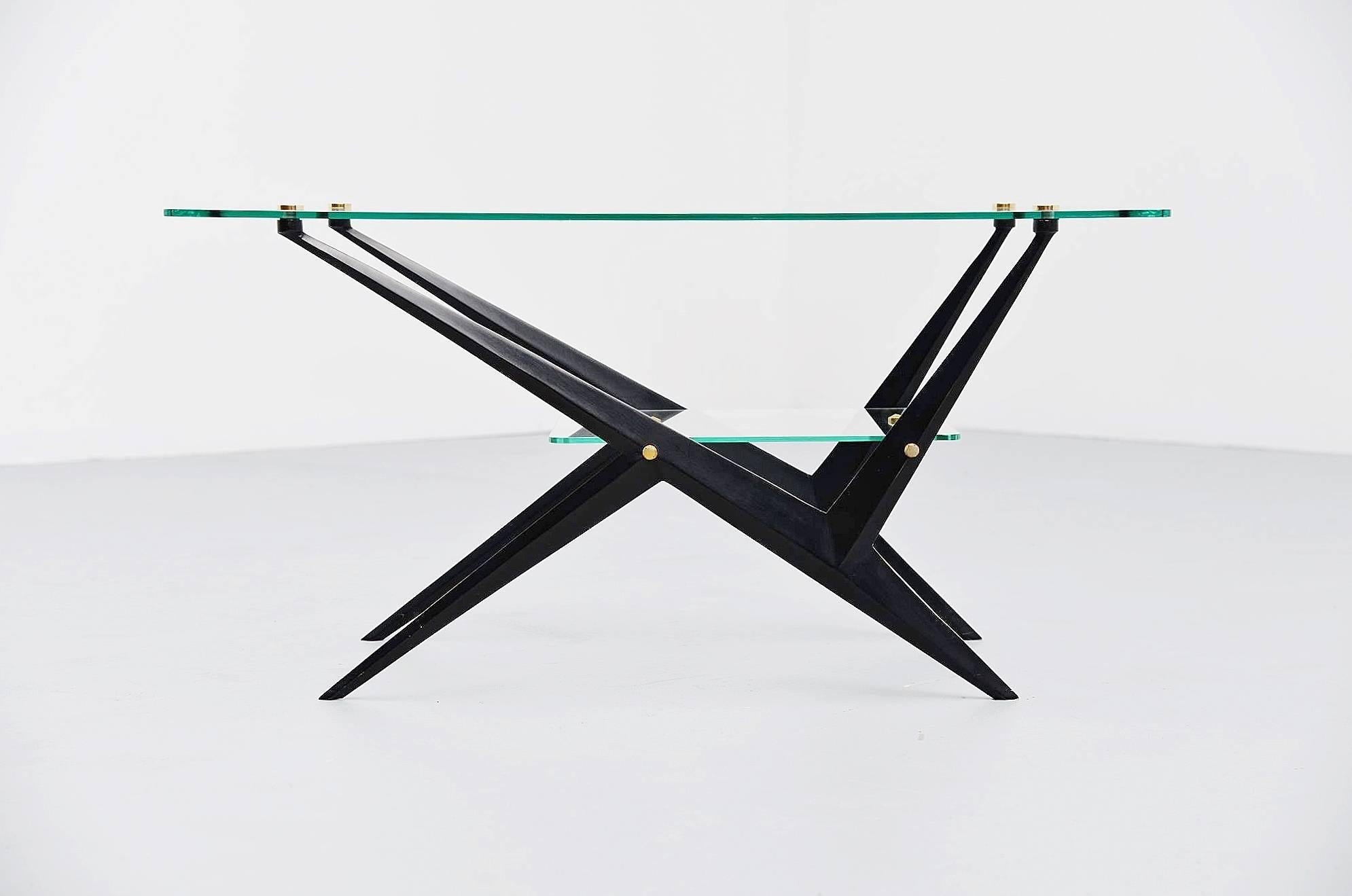 Nice and dynamic cocktail sofa table designed and made by Angelo Ostuni, Italy, 1950. This table has a black lacquered metal frame and the brass details attach the glass tops between and on the base. The table is in very good condition, there are