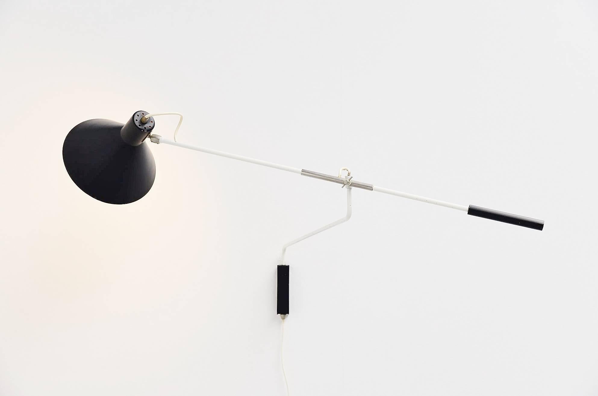 Nice and impressive sculptural counter balance wall lamp designed by J. J. M. Hoogervorst for Anvia Almelo, Holland, 1957. This amazing large wall lamp has an off white lacquered arm and black lacquered shade and weight. The lamp balances and
