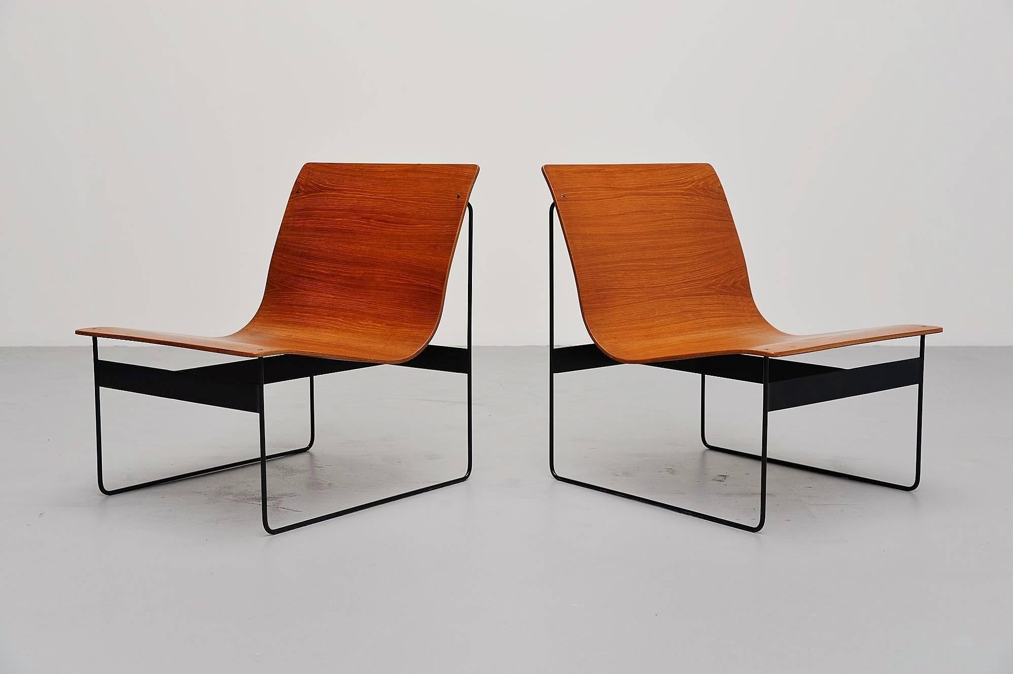 Amazing pair of lounge chairs designed by Günter Renkel for Rego, Germany, 1959. These chairs are made of teak plywood and have solid metal sophisticated sledge frames, black lacquered. The chairs have a very nice and warm grain to the wood and