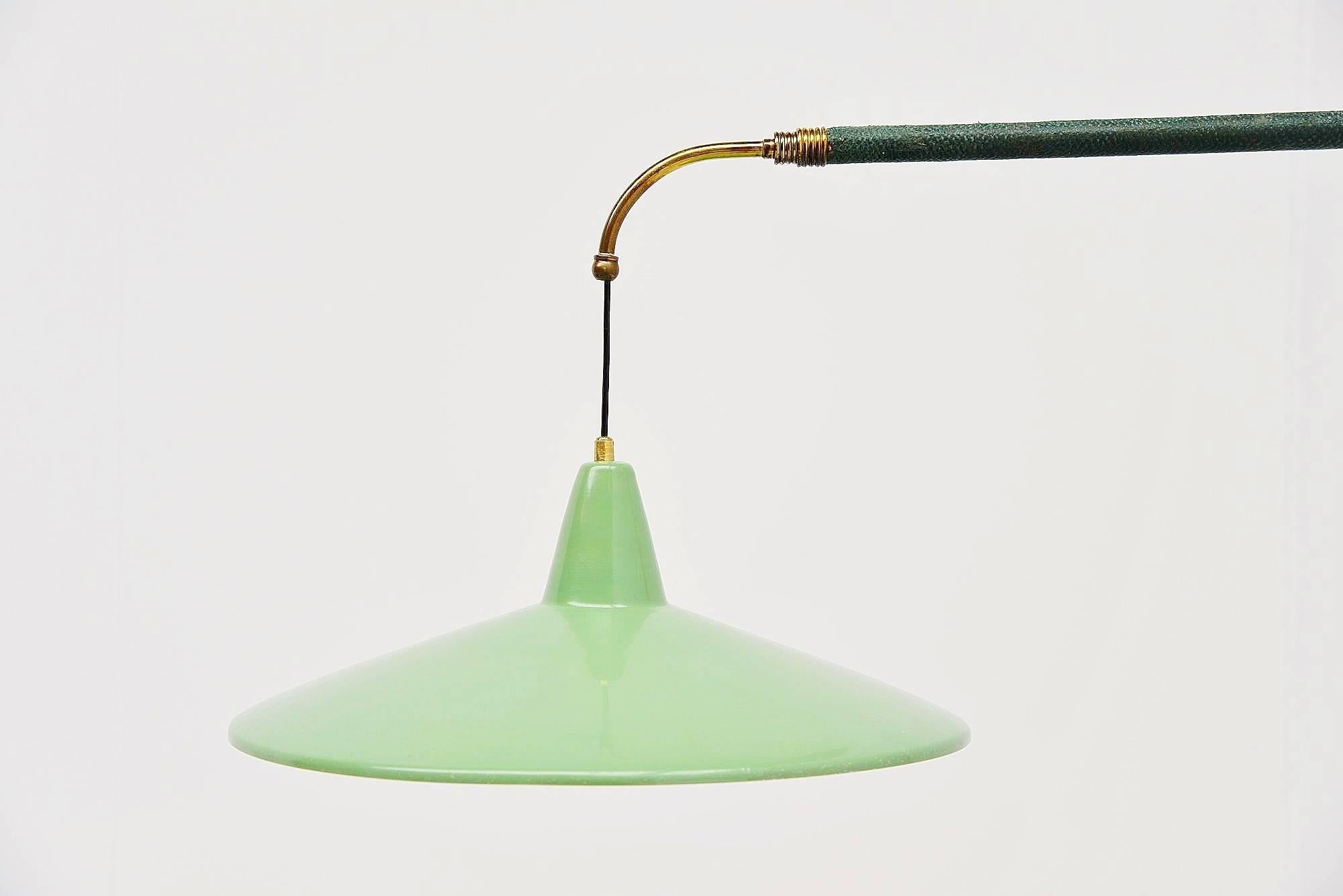 Very nice extendable wall lamp in the style of Arredoluce, Italy 1950. High quality wall lamp with brass extendable arm (extendable from 100 cm to 150 cm), covered with green leather. It has a brass weight and a very nice mint green shade. The lamp