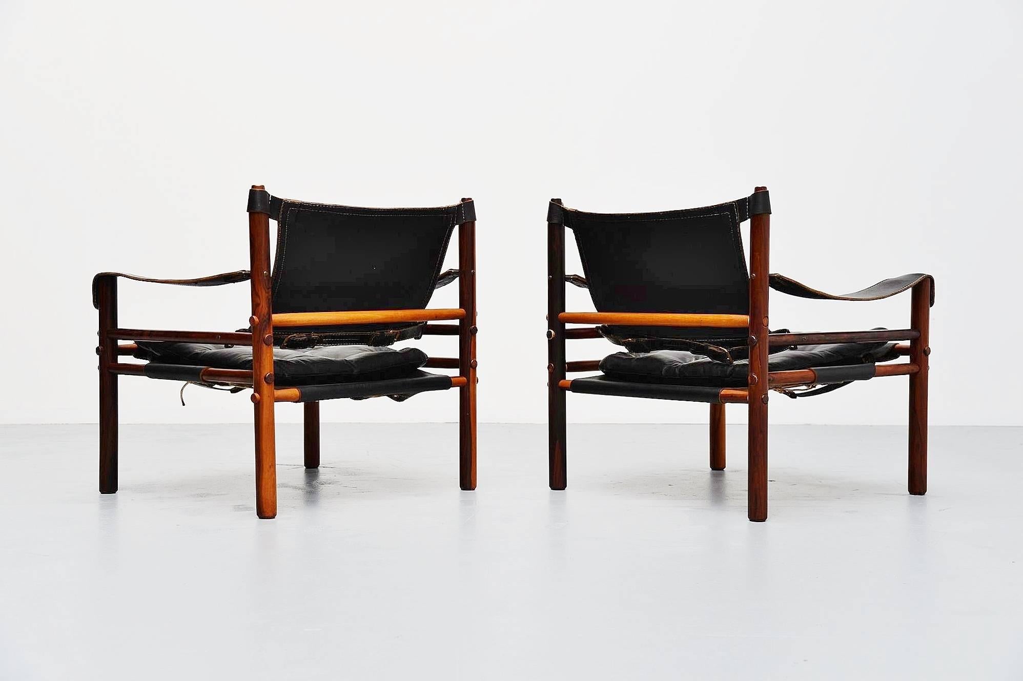 Excellent pair of Sirocco lounge chairs designed by Arne Norell, manufactured by Norell Mobler AB, Sweden 1964. These chairs have very nice grained solid rosewood frames and thick black leather seats with lovely patina. The chairs are fully in tact,