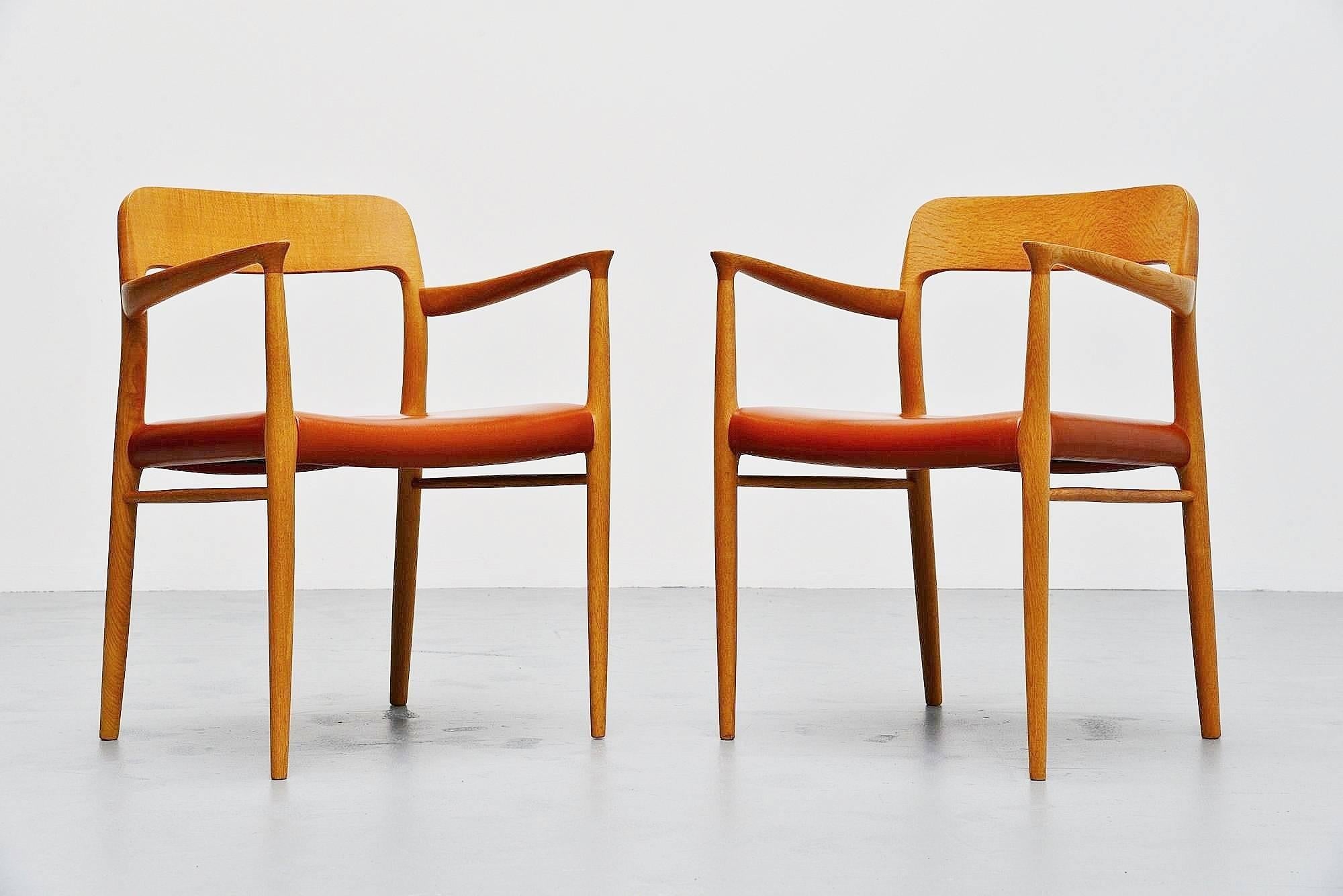 Very nice pair of arm chairs designed by Niels Otto Moller, manufactured by J.L. Møller Mobelfabrik, Denmark 1954. These chairs are made of solid oakwood and have very nice cognac leather upholstery. The chairs were hardly used by previous owner and