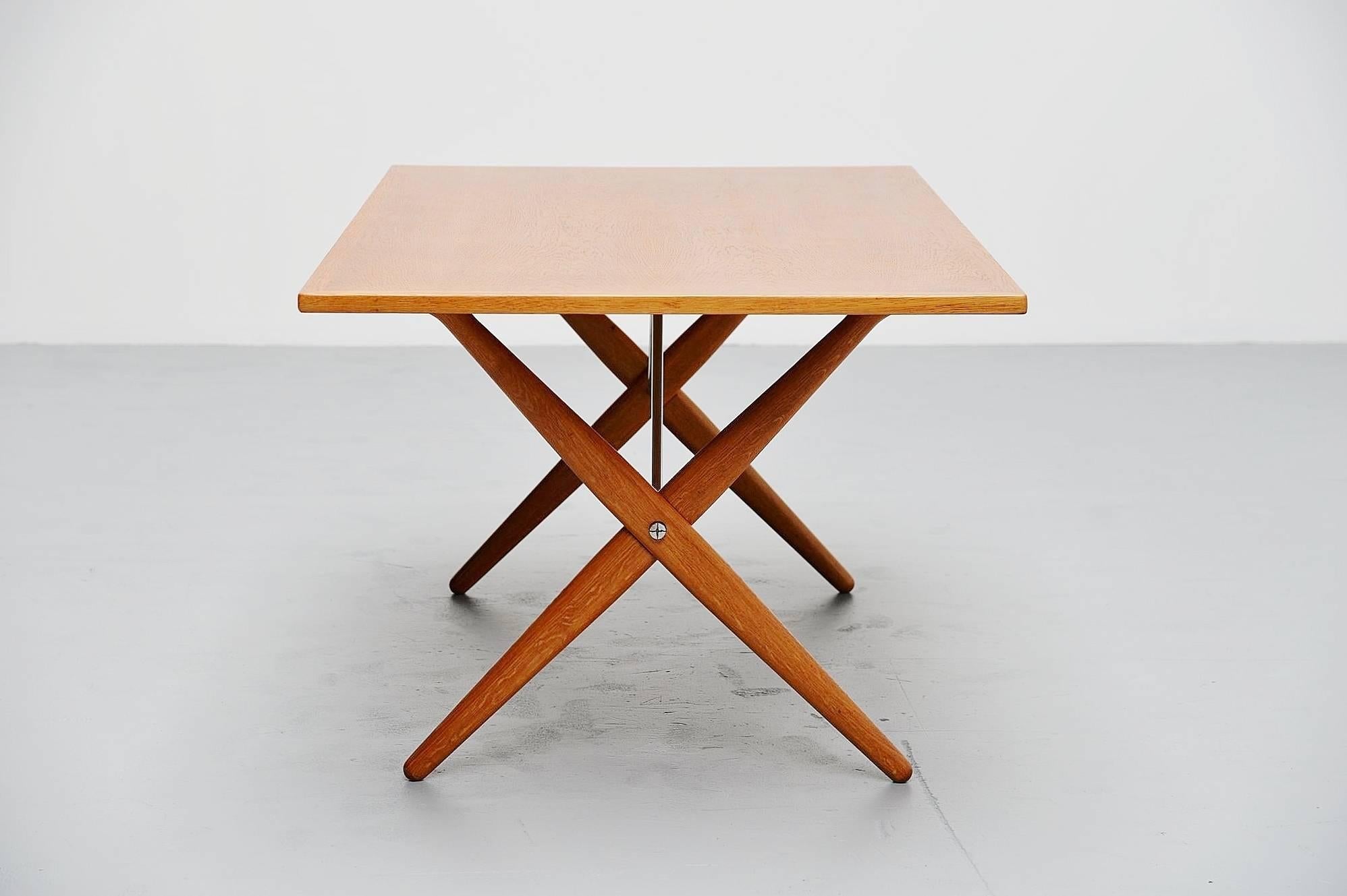 Iconic dining table mode AT-303 designed by Hans J. Wegner, manufactured by Andreas Tuck, Denmark, 1955. This table is made of solid oakwood and has very nice cross legged feet, supported with brushed steel tubular supports in the middle. The table