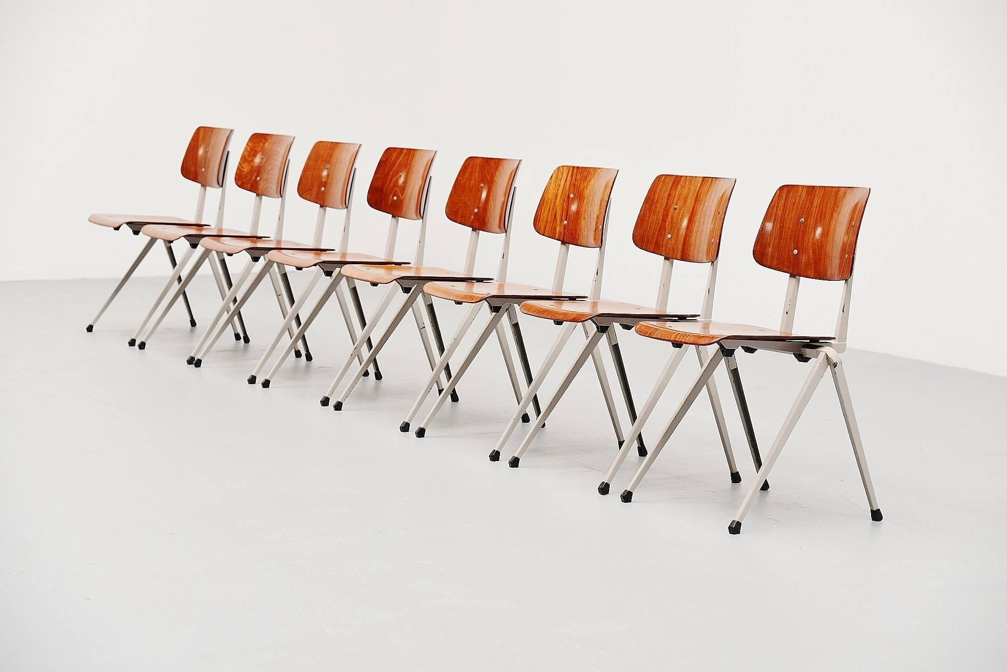 Nice and uncommon set of eight Industrial stacking chairs made and designed by Galvanitas Oosterhout, Holland 1970. These chairs have an Industrial grey lacquered metal frame with rubber feet and an cognac brown pagwooden seat and back. This is for
