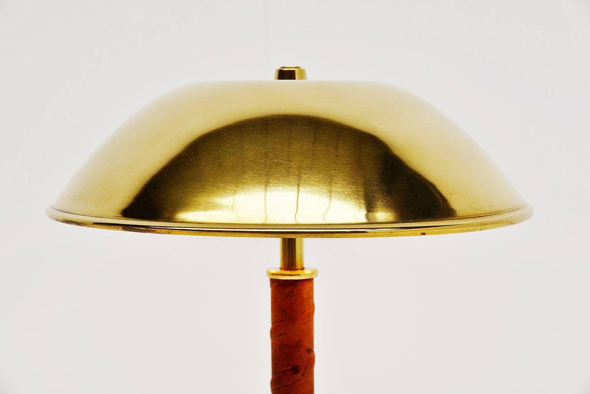 Highly decorative table lamp designed and made by ASEA Belysning, Sweden 1960. This table lamp is made of brass and has a very nice detailed leather ribbon around the bar. Give nice and warm light when lit and is in very nice clean shiny brass.