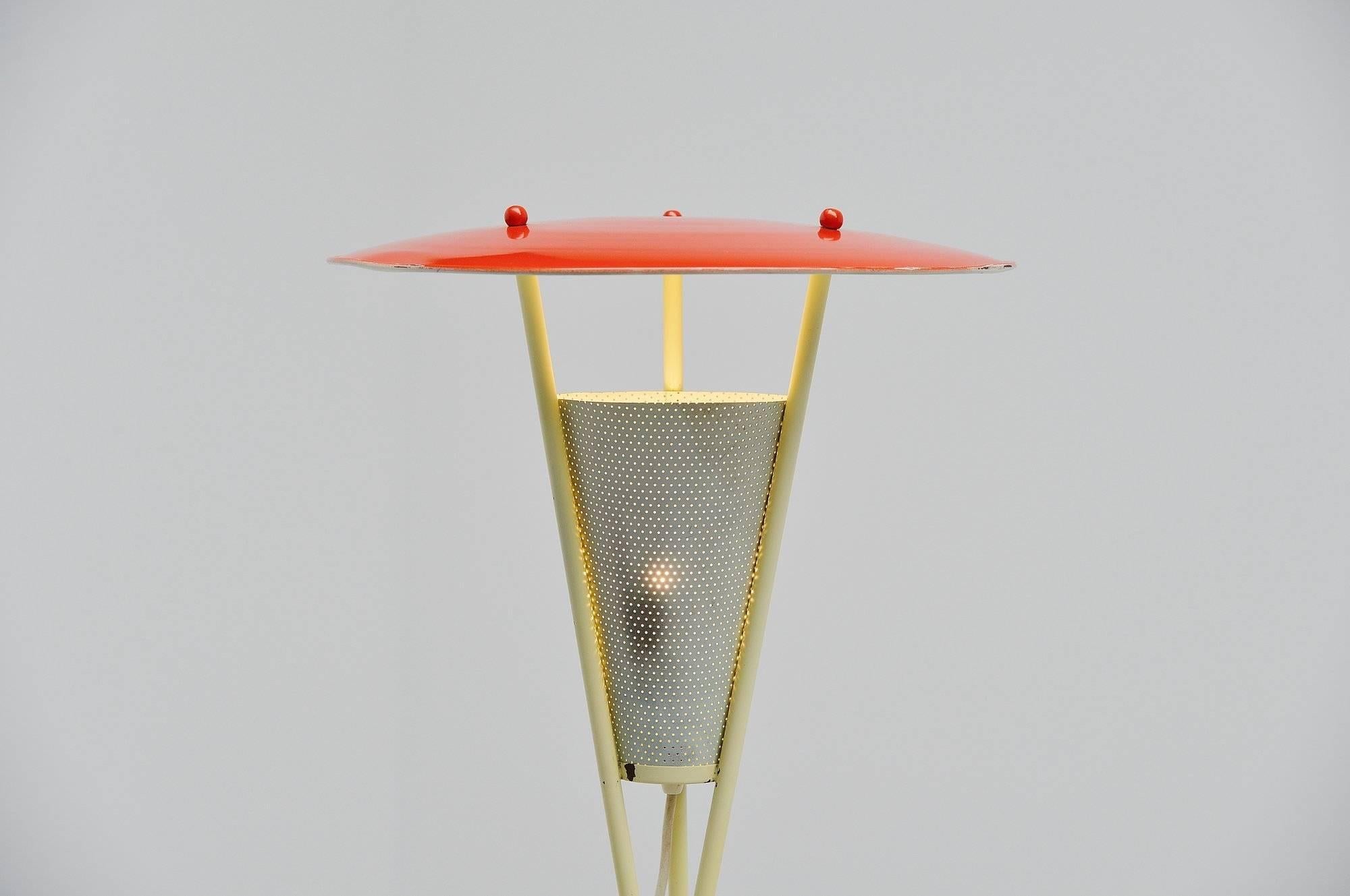 Sehr schöne Dreibein-Stehlampe von unbekanntem Hersteller oder Designer, Holland, 1950. Diese Lampe hat einen gelben Dreibeinfuß, der mit rotem Kunststoff umwickelt ist. Der Schirm ist rot lackiert und der gestanzte Diffusorschirm ist weiß lackiert.