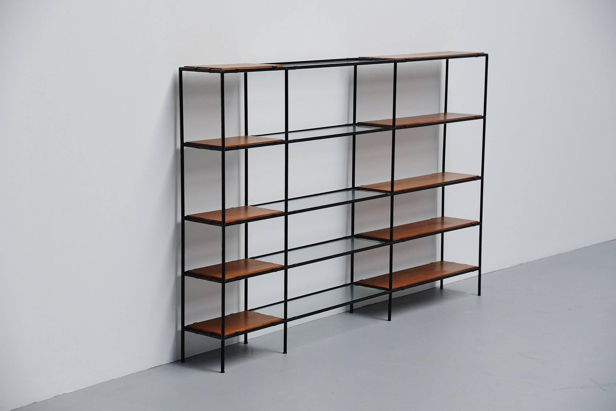 Nice small bookcase unit from the Abstracta series, designed by Poul Cadovius for Royal System, Denmark 1960. The cabinet is made of black lacquered tubular metal parts and it has teak wooden and glass shelves. This can be used as bookcase or