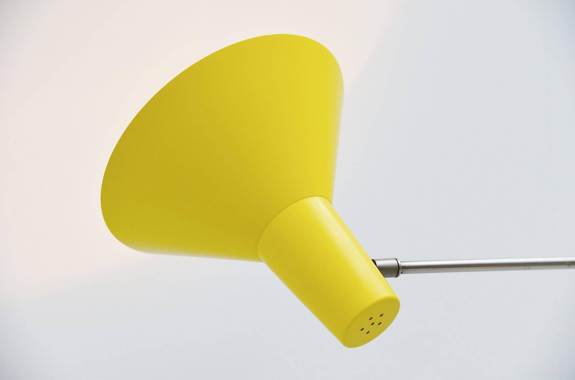 Nice adjustable wall lamp designed by Floris Fiedeldij and manufactured by Aritmeta Soest, Holland, 1960. This lamp has a nickel plated adjustable arm and bright yellow typical fifties color shade and wall plate. The lamp is in fantastic original