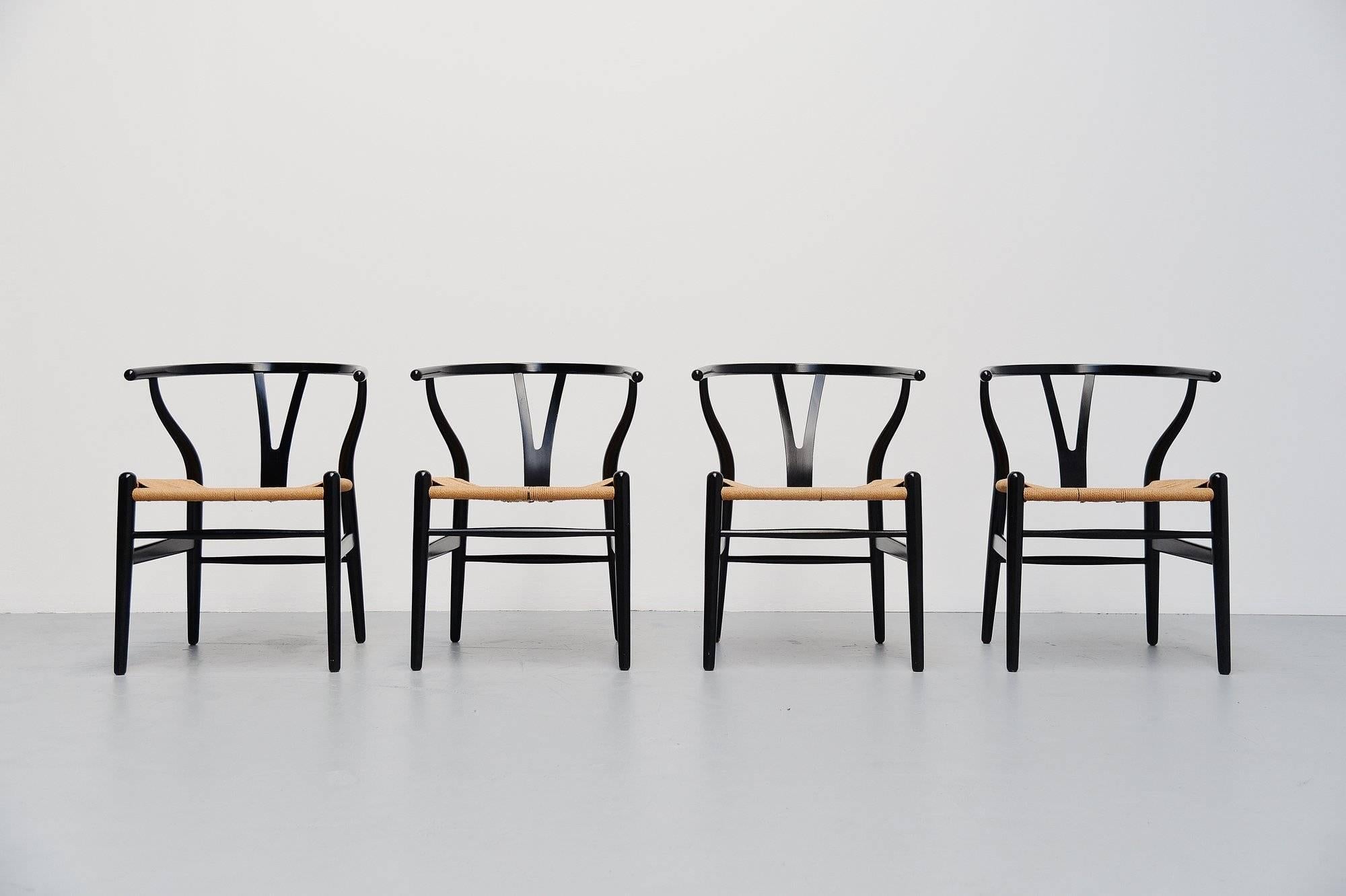 Very nice set of four so called Wishbone chairs model CH24 designed by Hans J. Wegner, manufactured by Carl Hansen & Son, Denmark, 1949. These nice early Wishbone chairs are in black painted beech and are in fantastic original condition with only