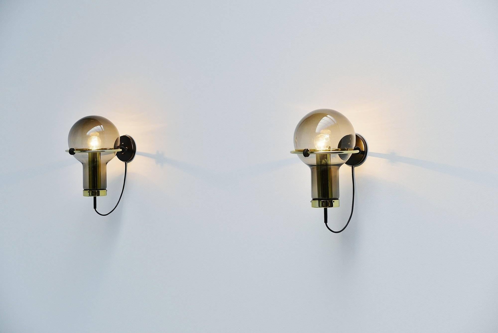 Very nice set of seven maxi globe wall lamps designed and made by RAAK Amsterdam, Holland, 1965. These lamps are called maxi globes and this is the smallest version available but still large for a wall lamp. The lamps have browngrey fume glass and a