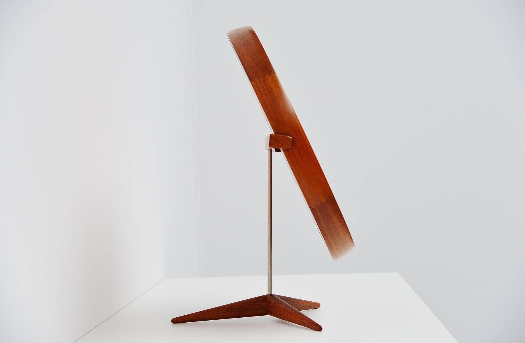 Super shaped teak table mirror designed by Uno and Osten Kristiansson for Luxus, Sweden, 1960. This solid teak mirror is very well crafted with nice dovetail connections in the rim and tripod base. Probably one of the nicest table mirrors ever made.