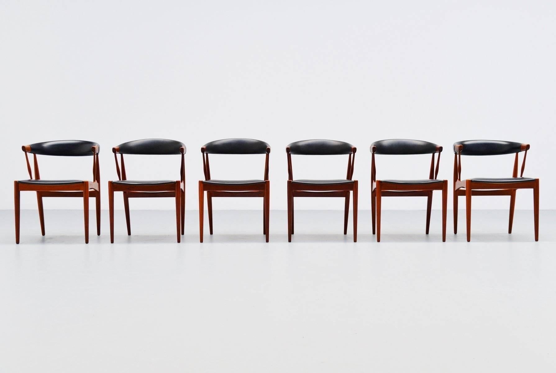 Fantastic set of dining chairs designed by Johannes Andersen for Brdr. Andersens Møbelfabrik A/S, Denmark, 1969. These nicely crafted chairs look a bit like the cowhorn chairs. They have solid teak frames and black vinyl upholstery which is original