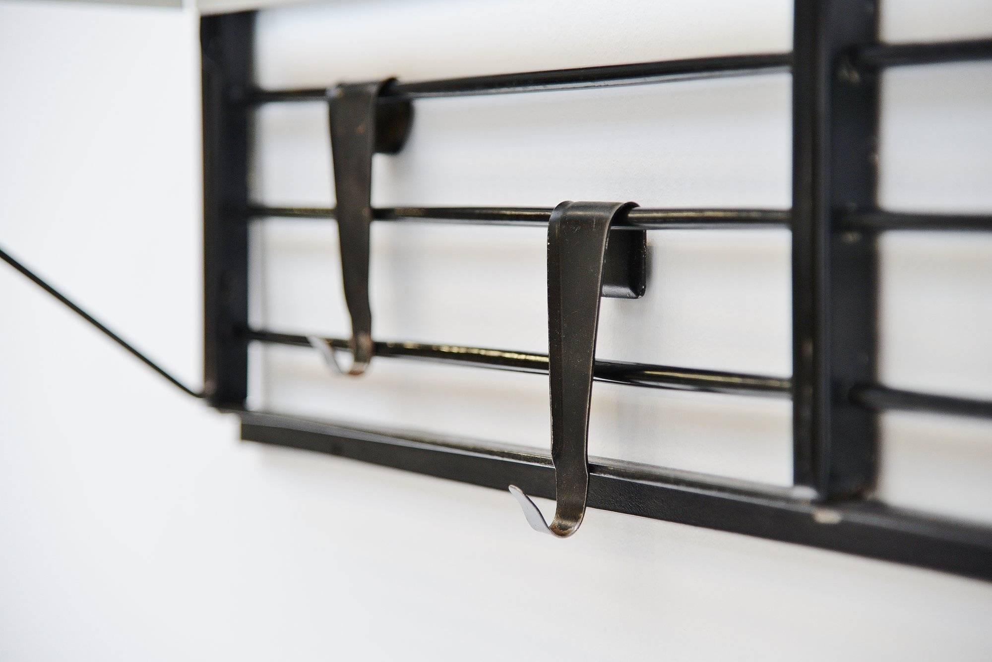 Rare small so called 'toonladder' coat rack designed by Tjerk Reijenga and manufactured by Pilastro, Holland, 1960. This coat rack has a black lacquered metal frame with white hooks and die cut hat rack. This example is a rare first production,
