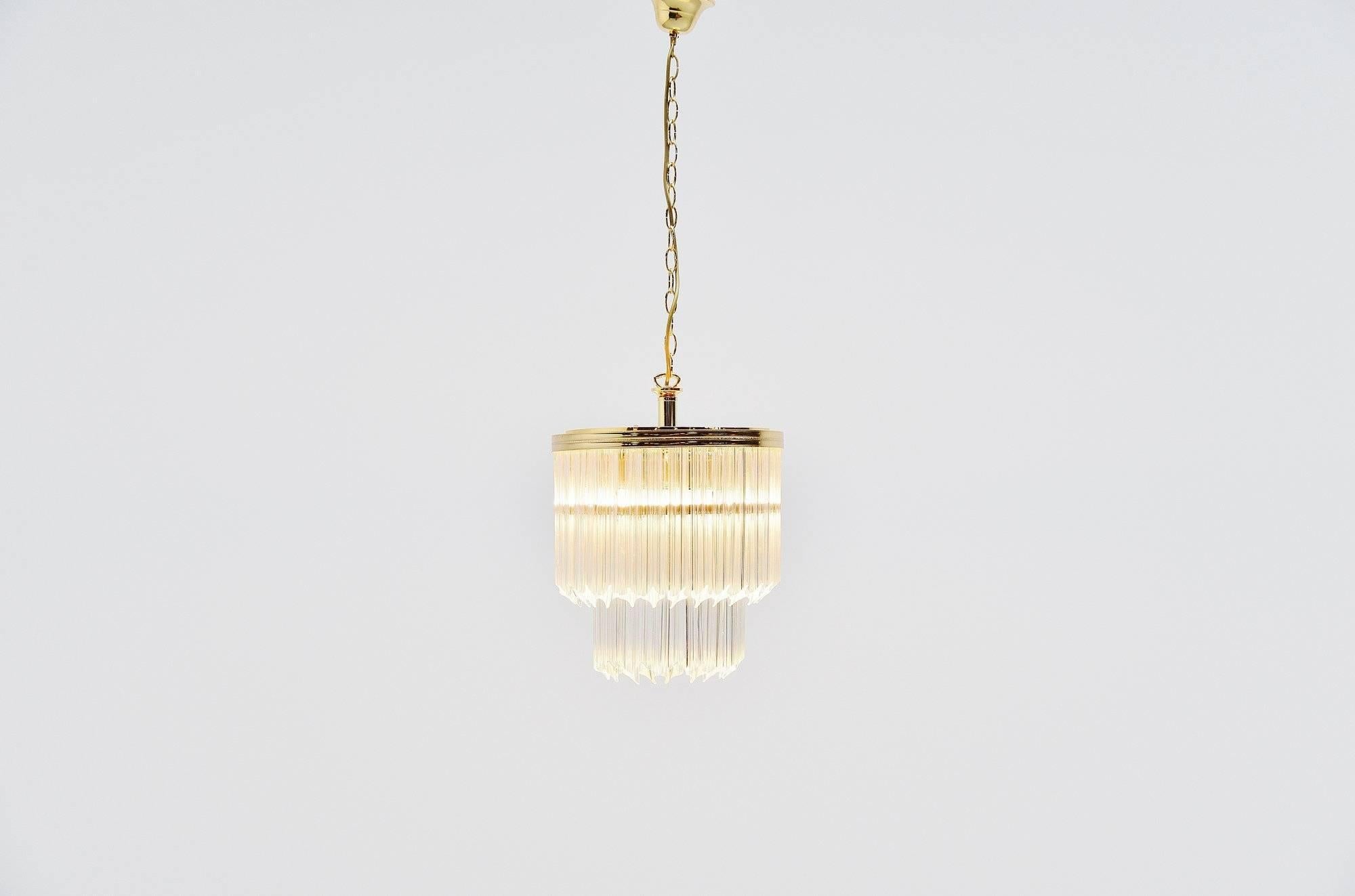 Super decorative chandelier designed by Paolo Venini and manufactured by Venini Murano, Italy, 1960. This nice sized chandelier has a brass hanging fixture and glass Venini bars, model asta quadrilobo. The lamp gives very nice and warm light when