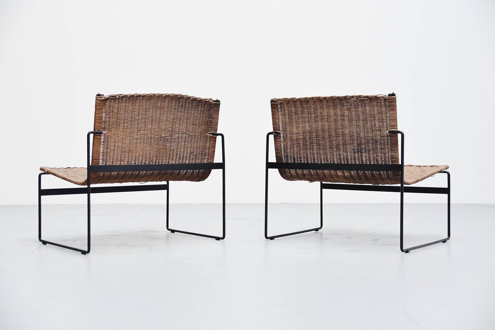 Super rare pair of light weighted lounge chairs designed by Gregorio Vicente Cortes and Luis Onsurbe and distributed by Metz & Co, Holland 1961. These rare Spanish chairs have a black painted metal frame and wicker seat. The wicker has a very nice