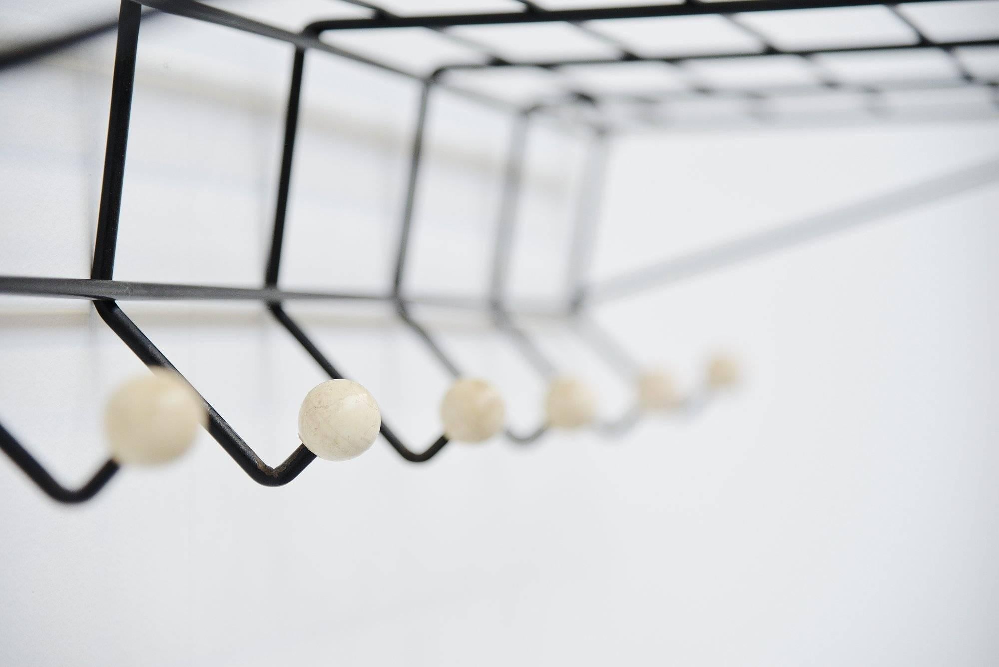 Very nice Industrial coat rack model DZ05 designed by Friso Kramer and manufactured by 't Spectrum, Holland, 1956. This is the largest version made and has a black painted metal wire frame with white painted wooden coat knobs. The coat rack is in