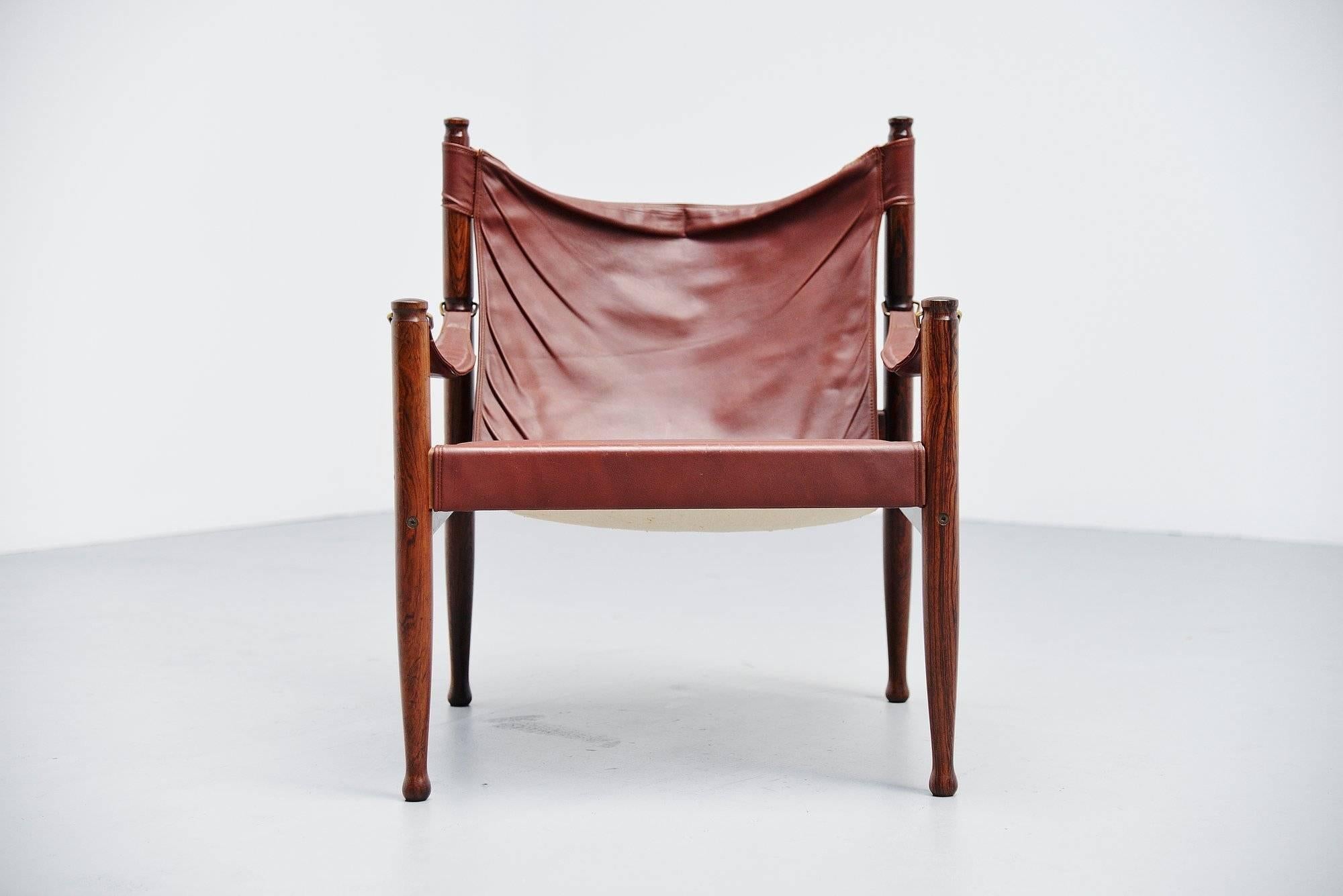 Stunning safari lounge chair designed by Erik Worts and manufactured by Niels Eilersen, Denmark, 1960. The design was based on a traditional English chair used by hunters in Africa and and Asia. Made of solid rosewood and reddish leather seat with