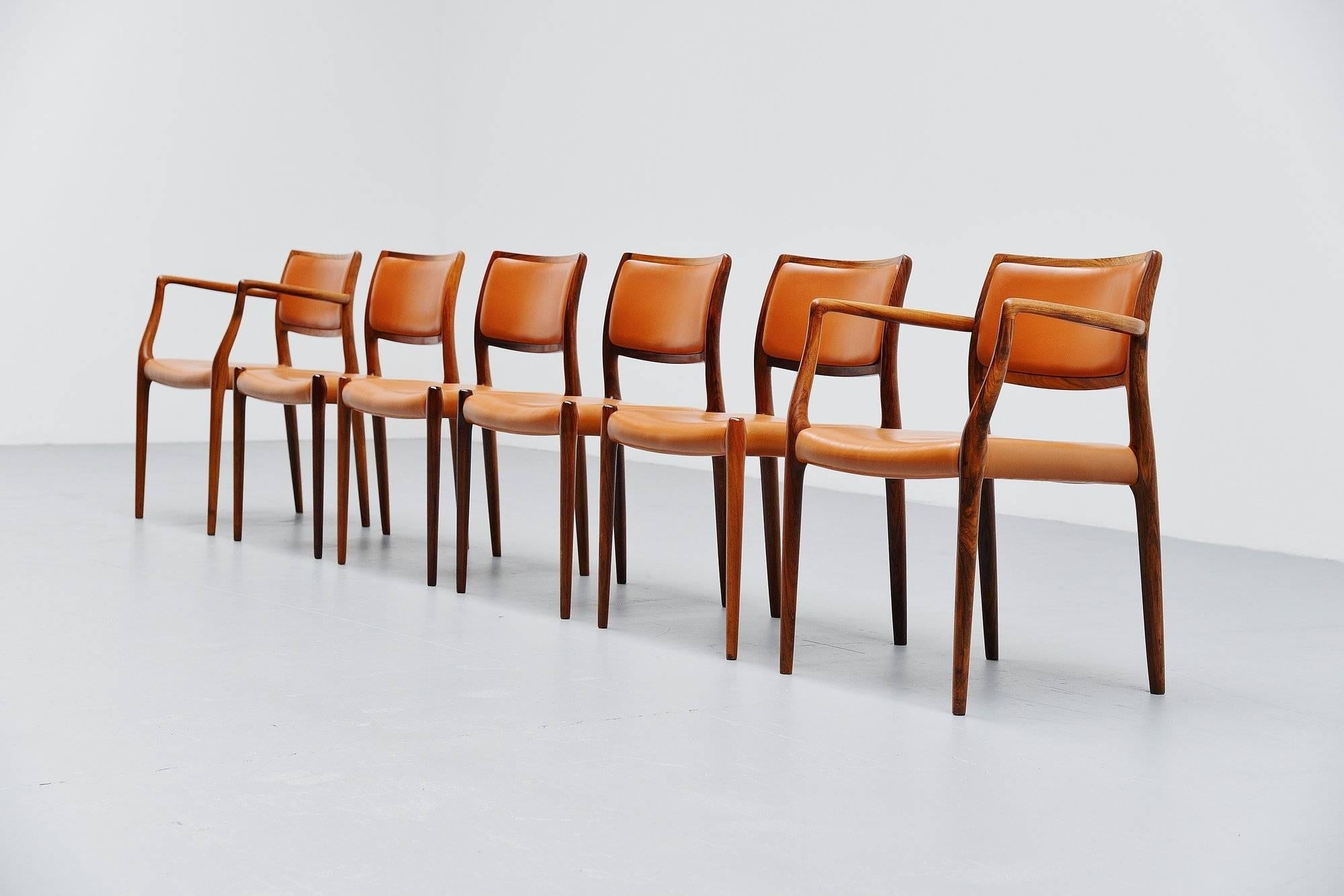 Very nice set of six rosewood chairs model 80 and model 65, designed by Niels Møller and manufactured by J.L. Møller Mobelfabrik, Denmark, 1966. The chairs have solid rosewood frames and original cognac leather upholstery with a very nice patina