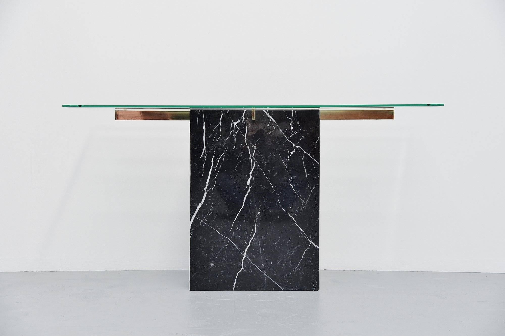 Nice and decorative console table made and designed by Artedi, Italy, 1970.This console table is made of black marbled and has a brass glass support. The glass has facet cut edges which are nice in detail. Very nice and high quality console table.