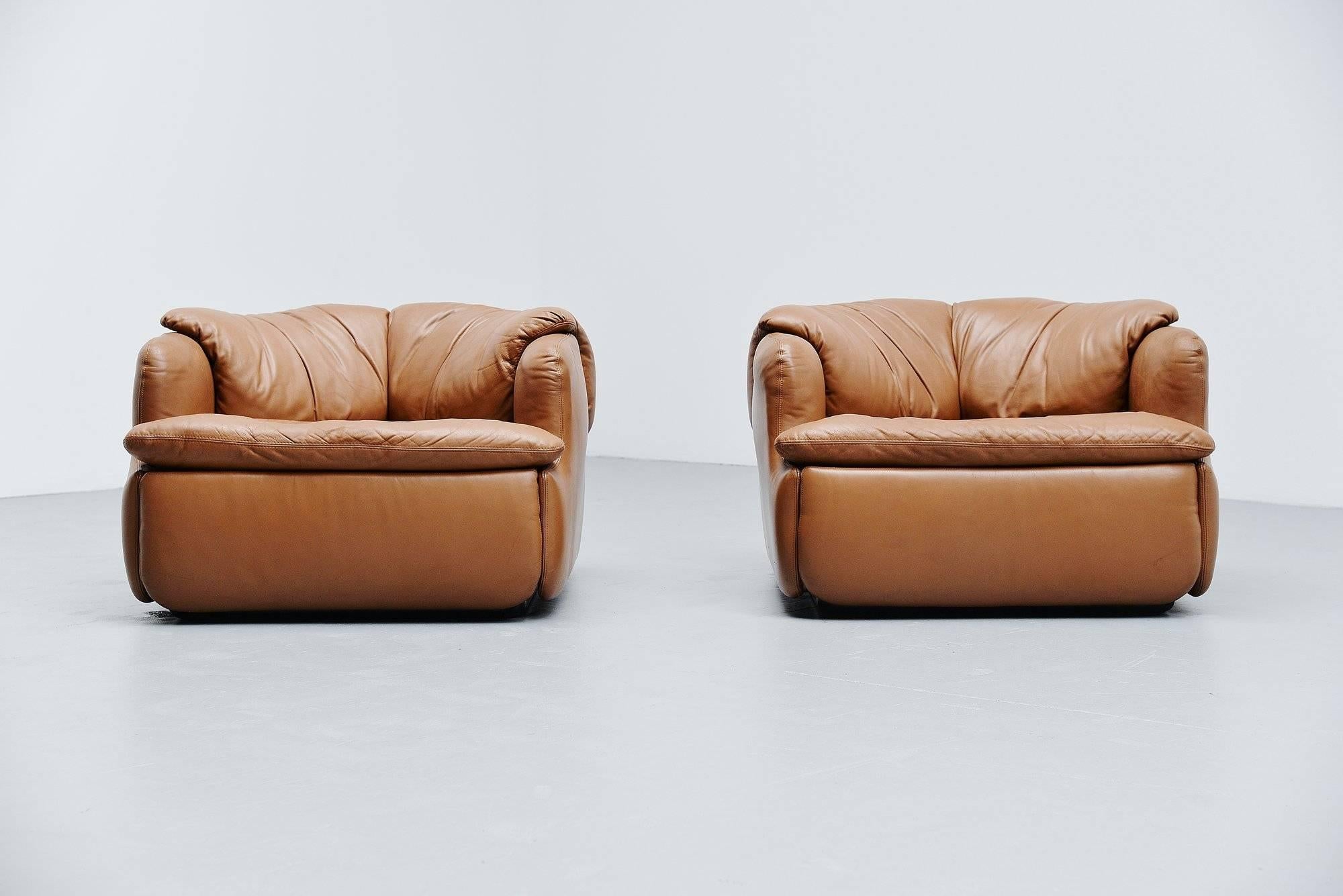 Comfortable pair of low 'Confidential' lounge chairs designed by Alberto Roselli and manufactured by Saporiti Italia, Italy, 1972. The chairs have a very nice camel colored leather seat and because they are completely filled with foam they are very
