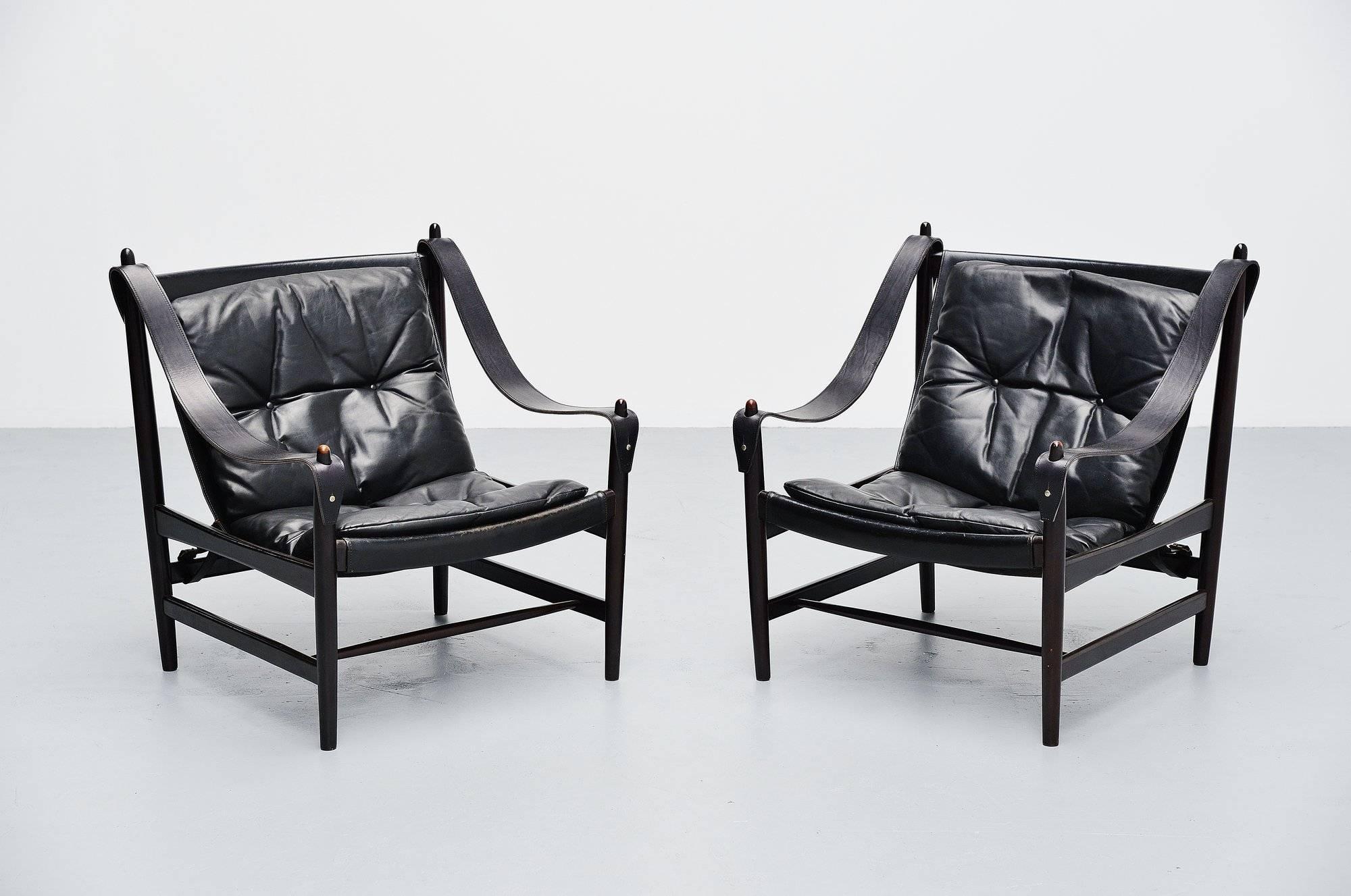 Exceptional pair of large 'safari' chairs made by unknown designer or manufacturer, in the style of Ole Wanscher, Denmark, 1960. The chairs have solid mahogany frames and black leather seats and cushions. Very nice and subtle shaped chairs in very
