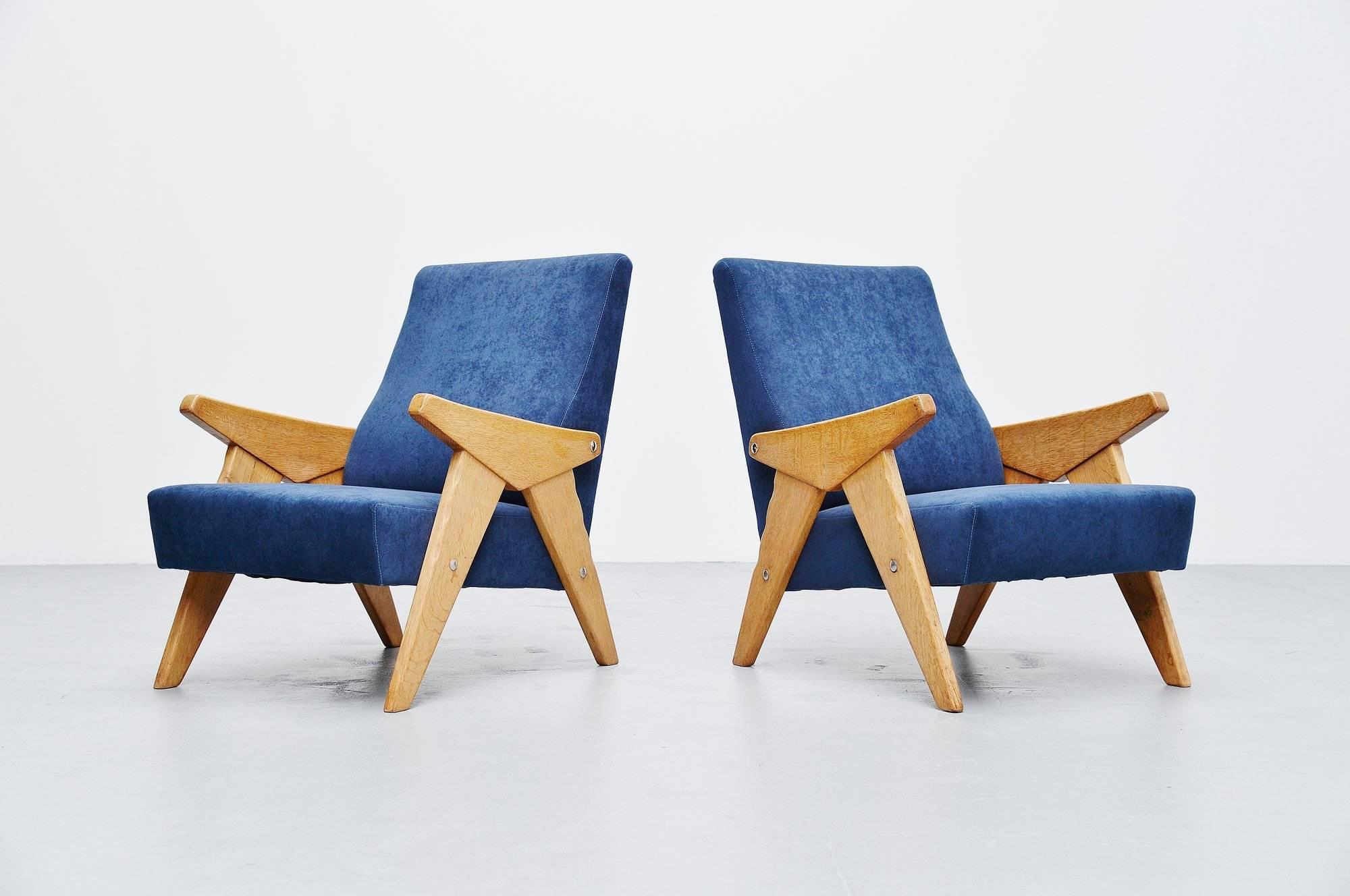 Stunning pair of lounge chairs designed and manufactured by Robert Guillerme et Jacques Chambron, France, 1960. The chairs have a solid oak wooden frame and newly upholstered velvet seats. Very nice looking and comfortable lounge chairs. Would adapt