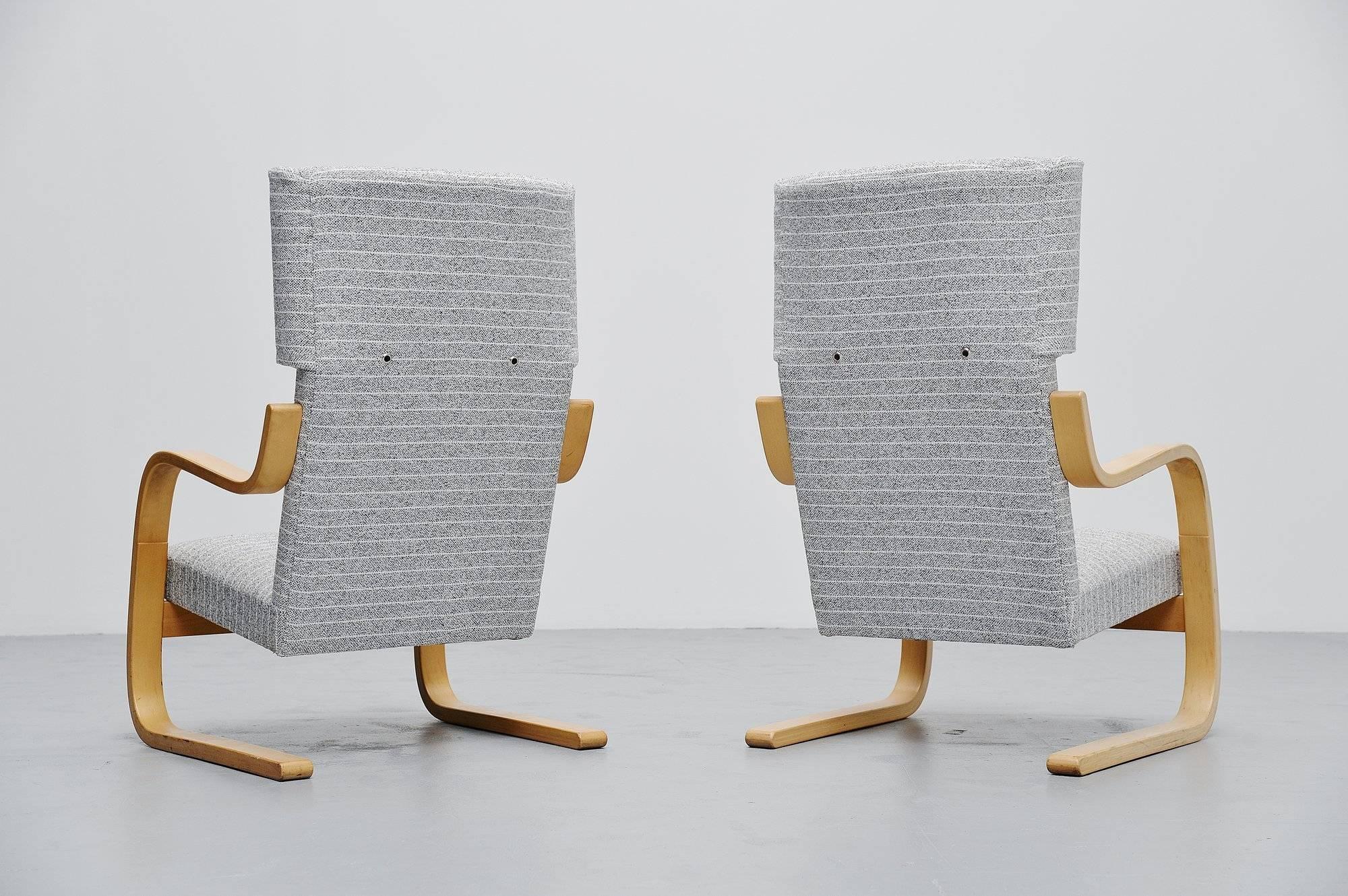 Stylish pair of wingback lounge chairs model 401 designed by Alvar Aalto for Artek, Finland, 1933. These chairs were purchased at Metz and Co. in the 1970s. The chairs have a birch plywood frame and newly upholstered light grey striped fabric. The