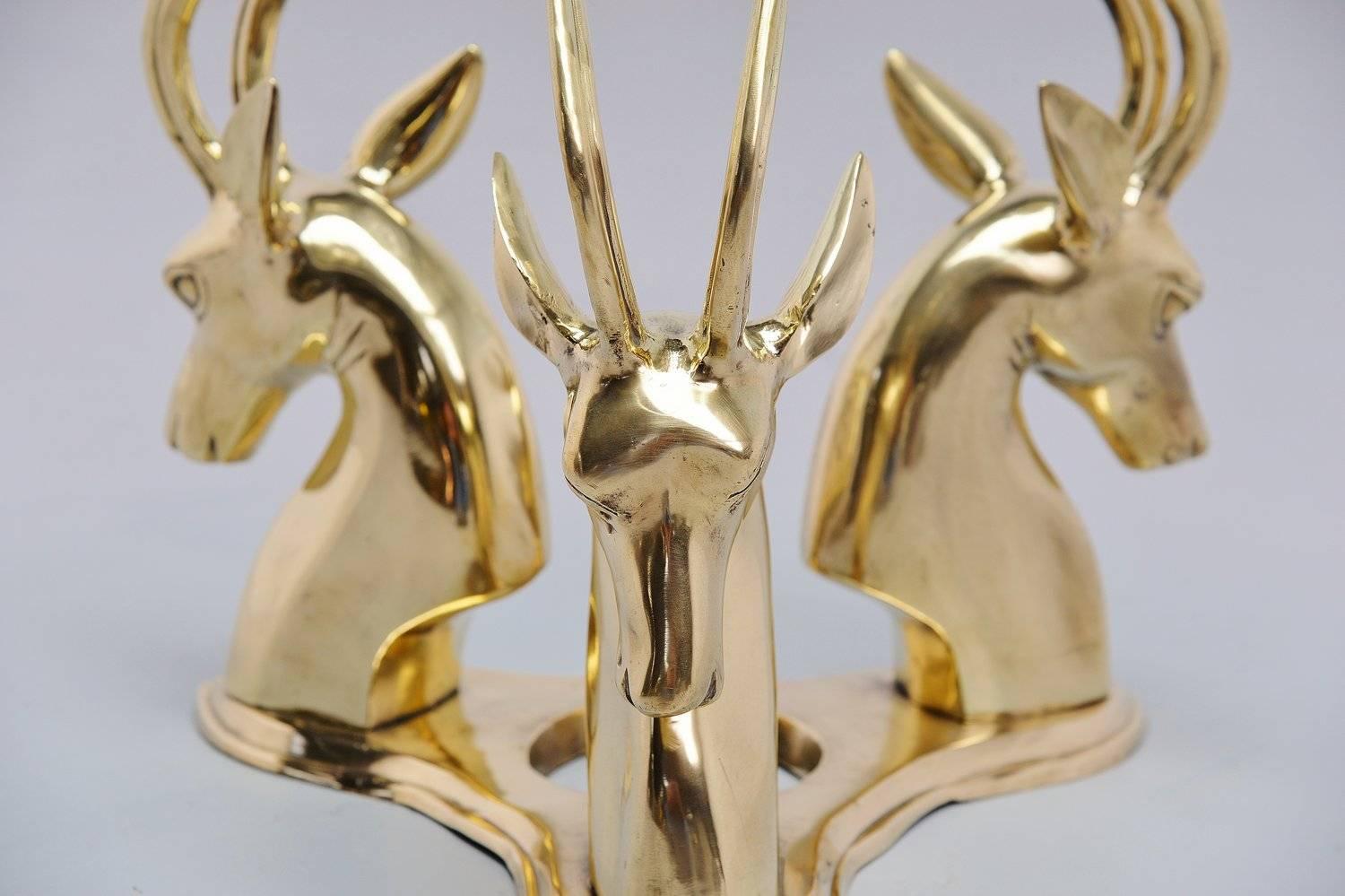 This table is made of solid bronze and has 3 antelopes supporting a round glass top. It could be a design by Jacques Duval-Brasseur who worked a lot with animals in his furniture. The table is in very shiny and clean condition and would be a real