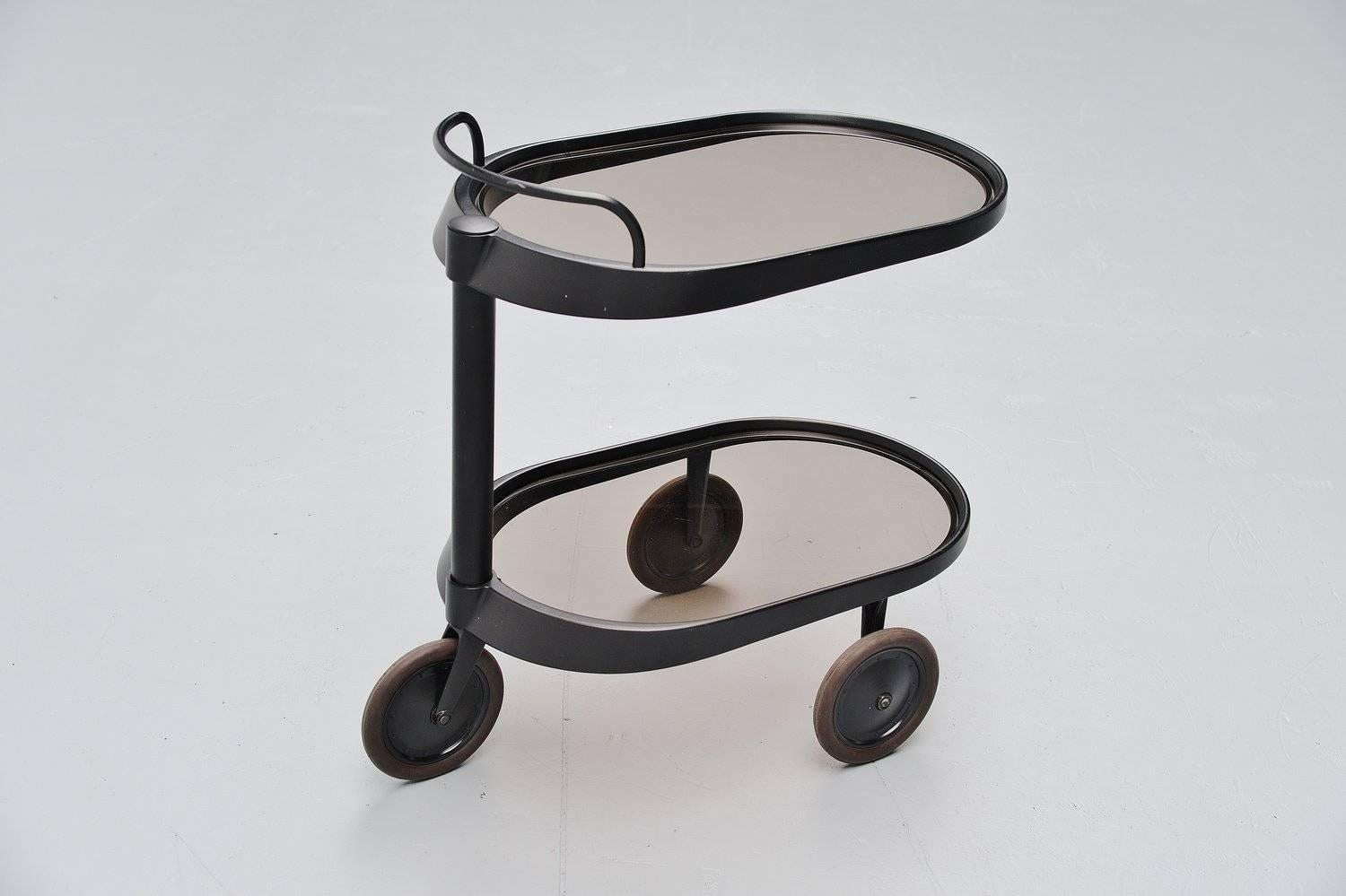 Very nice bar cart designed by Enzo Mari for Alessi, Italy 1989. This rare cart is no longer in production and therefor a real collectible. It is made of solid aluminum, black lacquered and it has 2 smoked glass trays. The cart is marked Alessi on