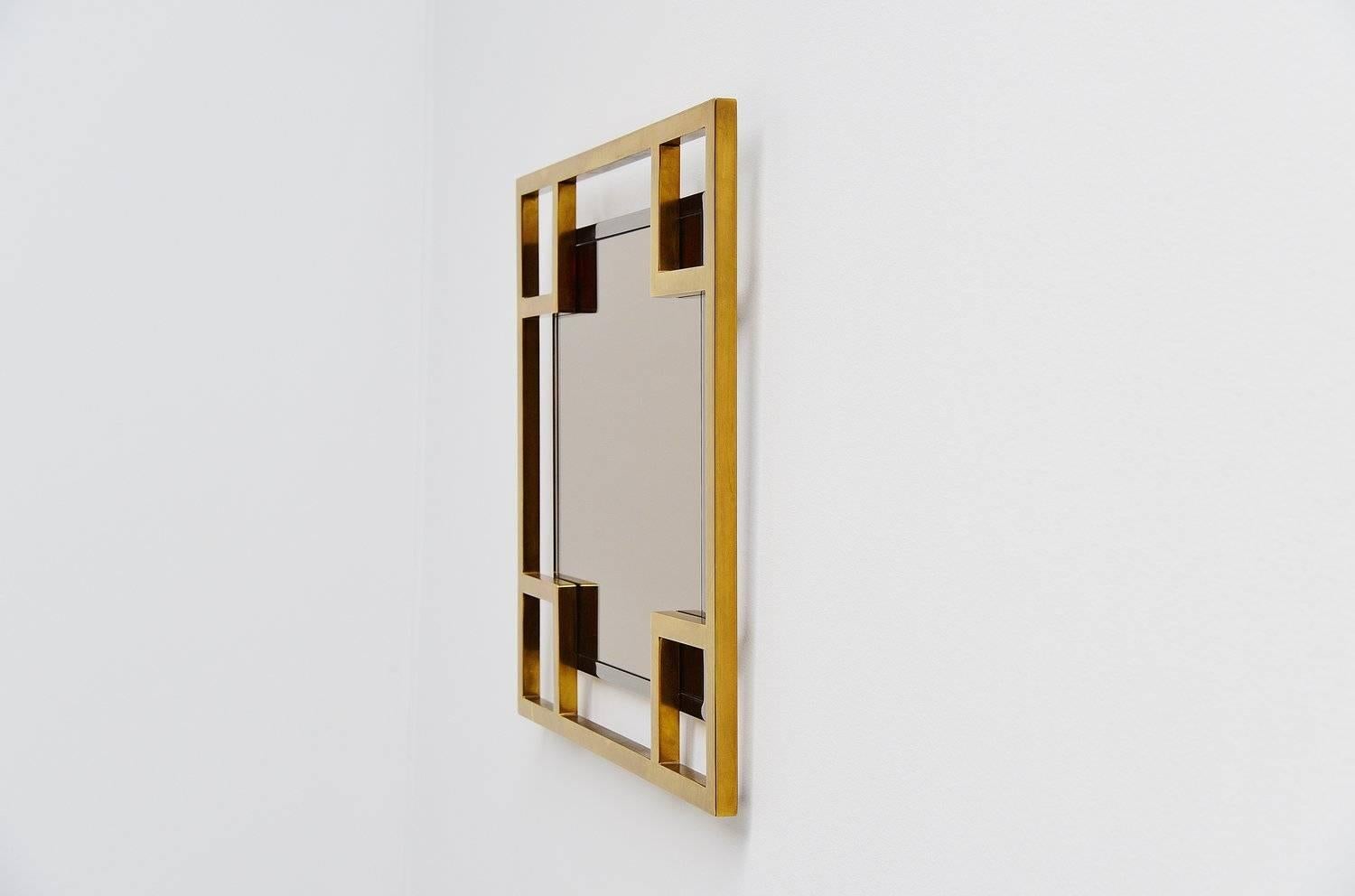 Excellent wall mirror by Maison Jansen, France, 1970. This high quality wall mirror was made of brass and chrome details and has a fume glass mirror. Heavy quality mirror and very nicely made. Easy to wall hang using only one screw. Can be used in