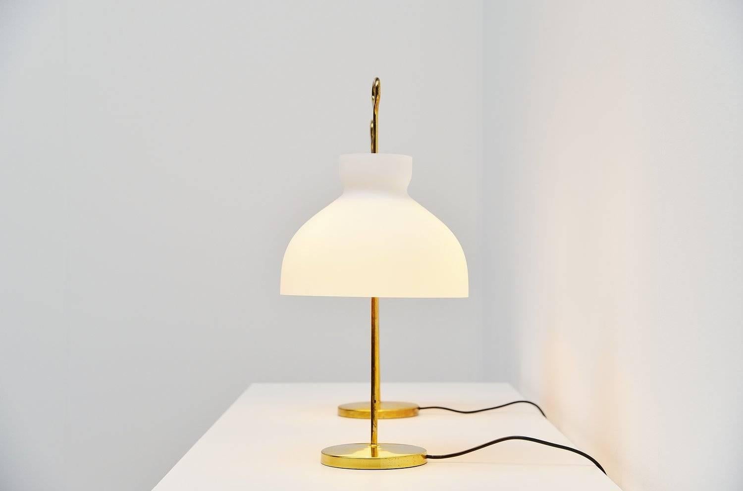 Fantastic pair of table lamps designed by Ignazio Gardella for Azucena, Italy 1956. These lamps ar from the first production and have a brass foot with a white frosted glass shade on top. The lamps give fantastic light when lit and look amazing in a