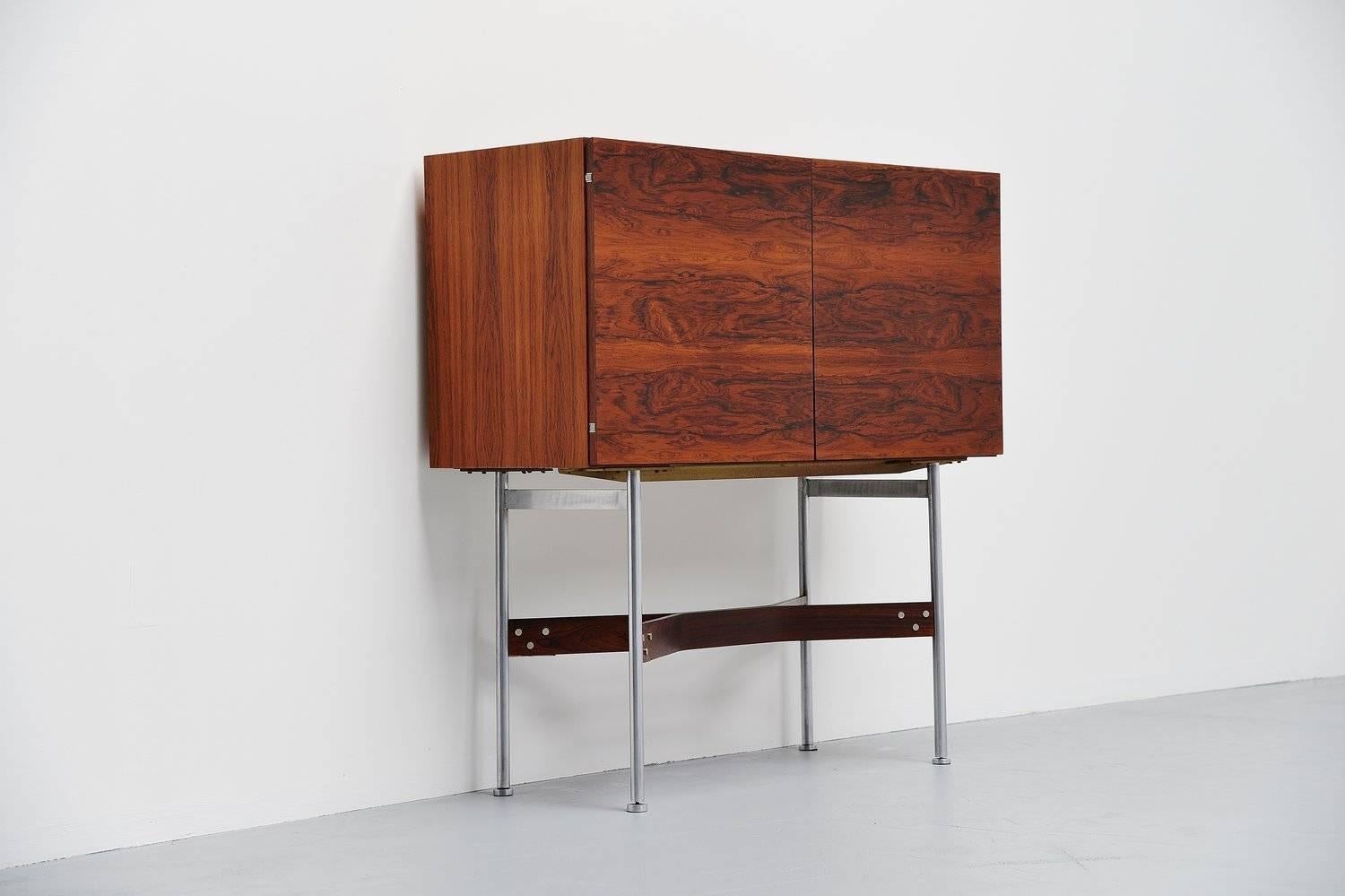 Stunning dry bar cabinet designed by German designer Rudolf Bernd Glatzel for Fristho Franeker, Holland 1956. This amazing shaped cabinet has a fantastic grain to the rosewood veneer. This bar has a brushed steel tubular frame supported by 2