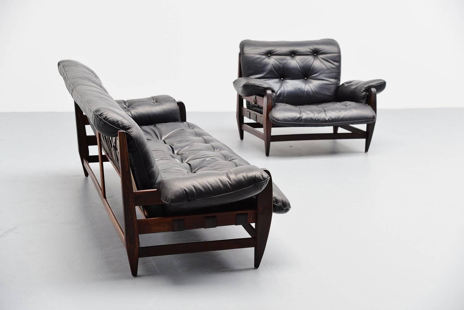Fantastic sofa set designed by Jean Gillon for Italma Wood Art, Brazil 1965. This amazing set has a solid jacaranda rosewood frame and black leather padded cushions. The singles are made of black leather too and show a very nice patina. 2 Seems are