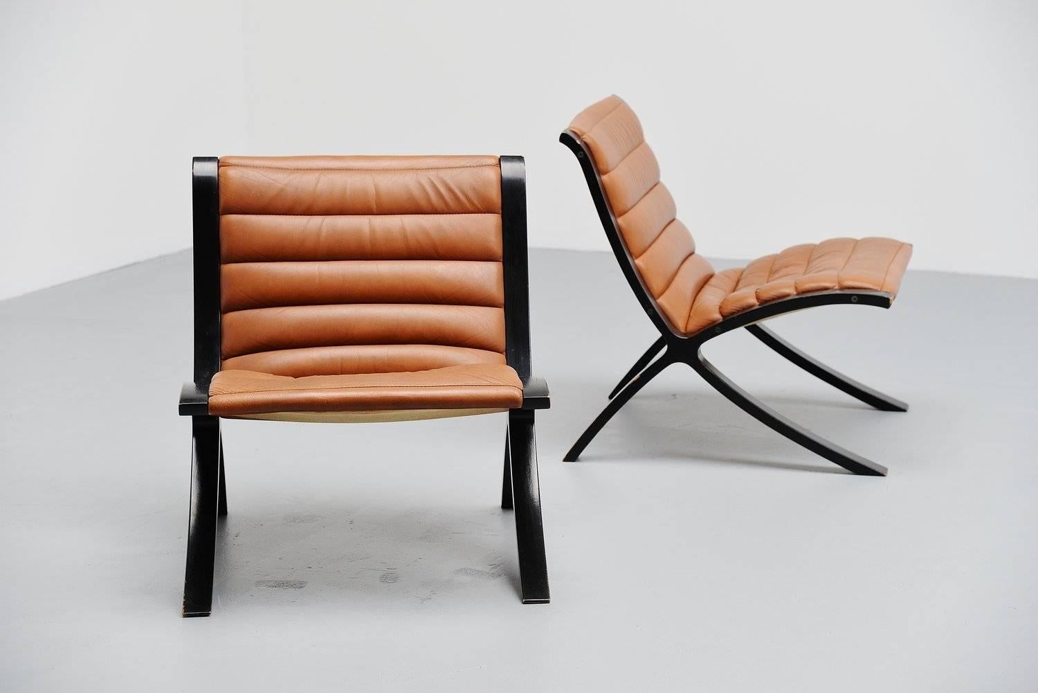 Nice pair of easy chairs model X-chair designed by Peter Hvidt & Orla Mølgaard Nielsen for Fritz Hansen, Denmark, 1979. These chairs have a black lacquered beech wooden frame and brown leather seats. The chairs are in original condition, there is