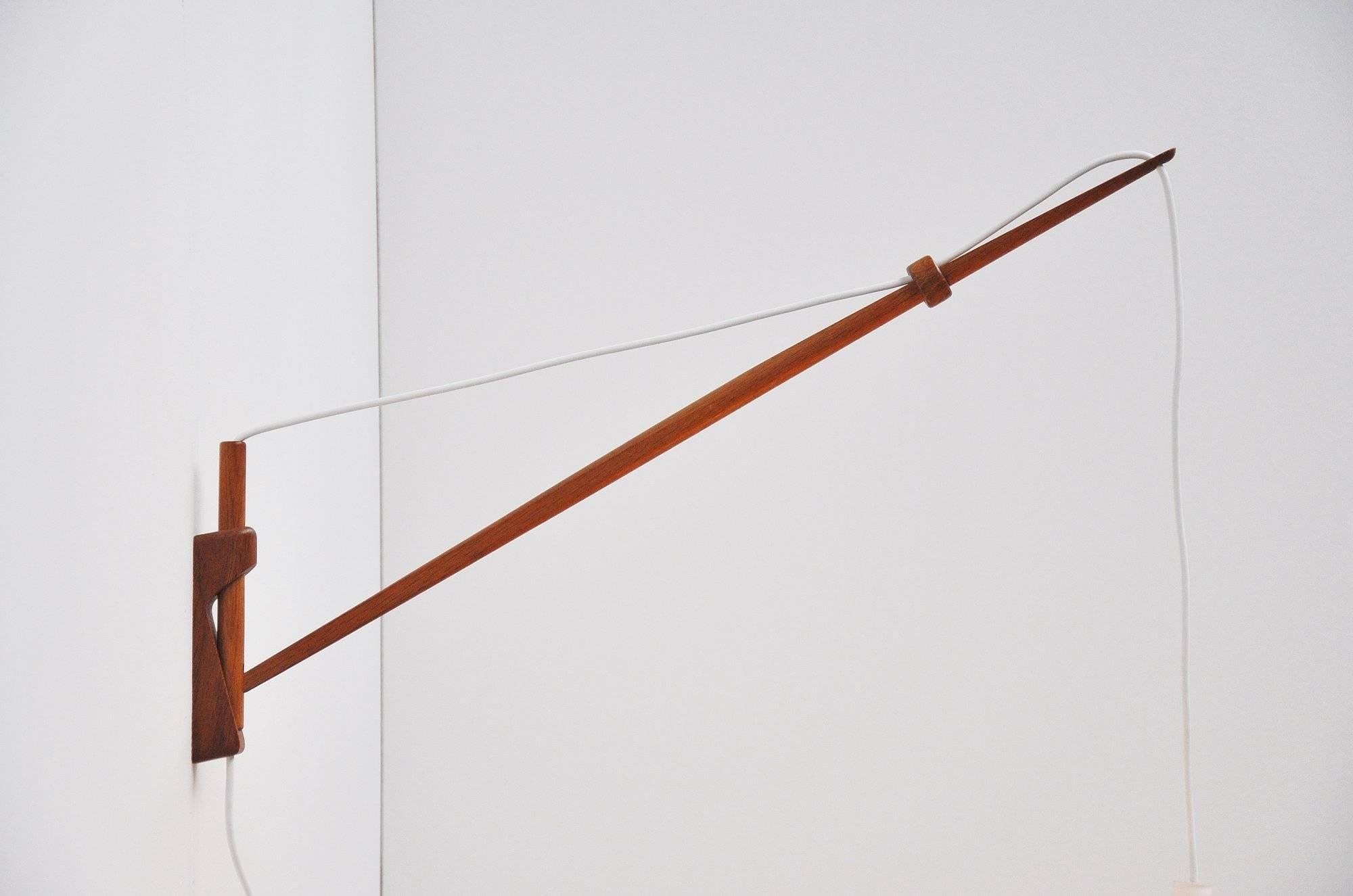 Beautiful teak arc wall lamp designed by Lisa Johansson-Pape for Stockmann-Orno, Finland 1954. This rare and early wall lamp designed by Lisa Johansson Pape is very hard to find. The combination of teak and frosted glass looks magnificent. The arm
