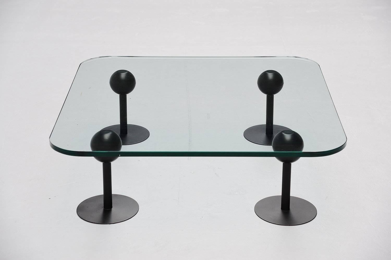 Collectible coffee table designed by Philippe Starck for Les Trois Suisses, France, 1982. This table exist from four black bases with rubber balls on top supporting a thick glass top. Very nice modernist shaped table. The glass is in very good