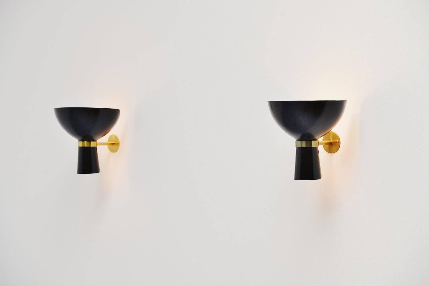 Very nice pair of Stilnovo sconces, Italy, 1950. These amazing shaped wall lamps have a bit Serge Mouille shaped shades black lacquered and they have brass arms. These amazing lamps give very nice warm indirect diffused light. Easy to wall hang