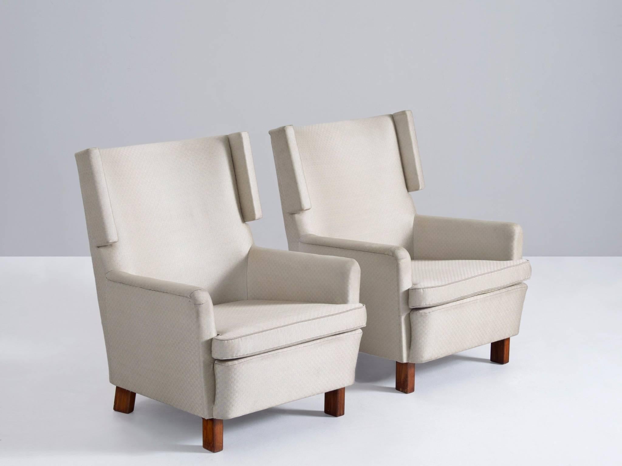 Pair of wingback chairs, fabric and wood, Sweden, 1960s.

Very nice designed pair of Swedish Mid-Century armchairs. Interesting shapes with nice wingback detail. The 'ears' correspond with the wooden legs of the chair. Comfortable lounge chair.