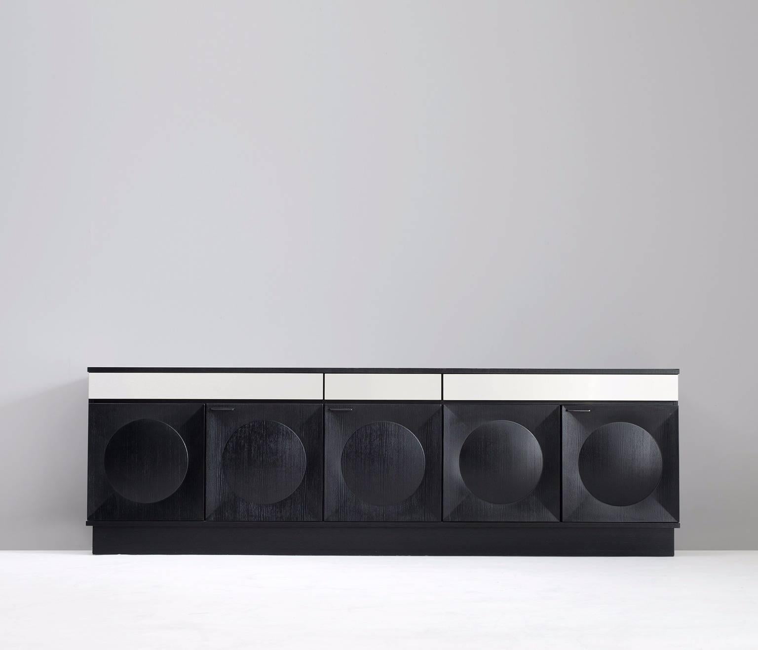 Black brutalist credenza, in oak and aluminium, European, 1970s. 

Sturdy black ebonized credenza with graphical designed door panels. Five-door panels, each with a three-dimensional pattern of circles and diagonal lines, which gives the cabinet a