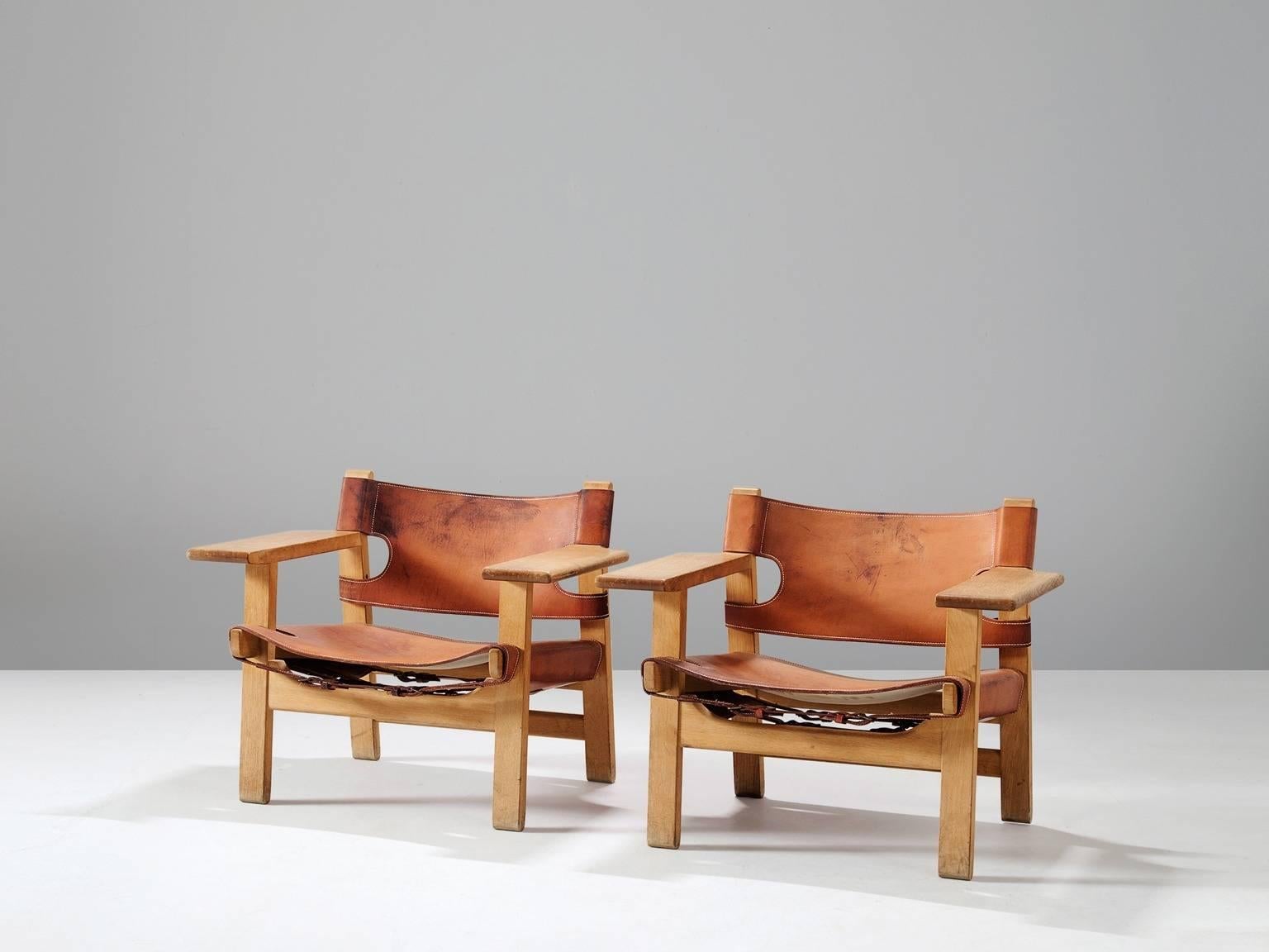 Pair of 'Spanish Chairs', in solid oak and cognac leather, by Børge Mogensen for Fredericia Stolefabrik, Denmark 1958. 

This well known design by Mogensen has a very strong appearance. The sincere construction and ditto type of upholstery, give the