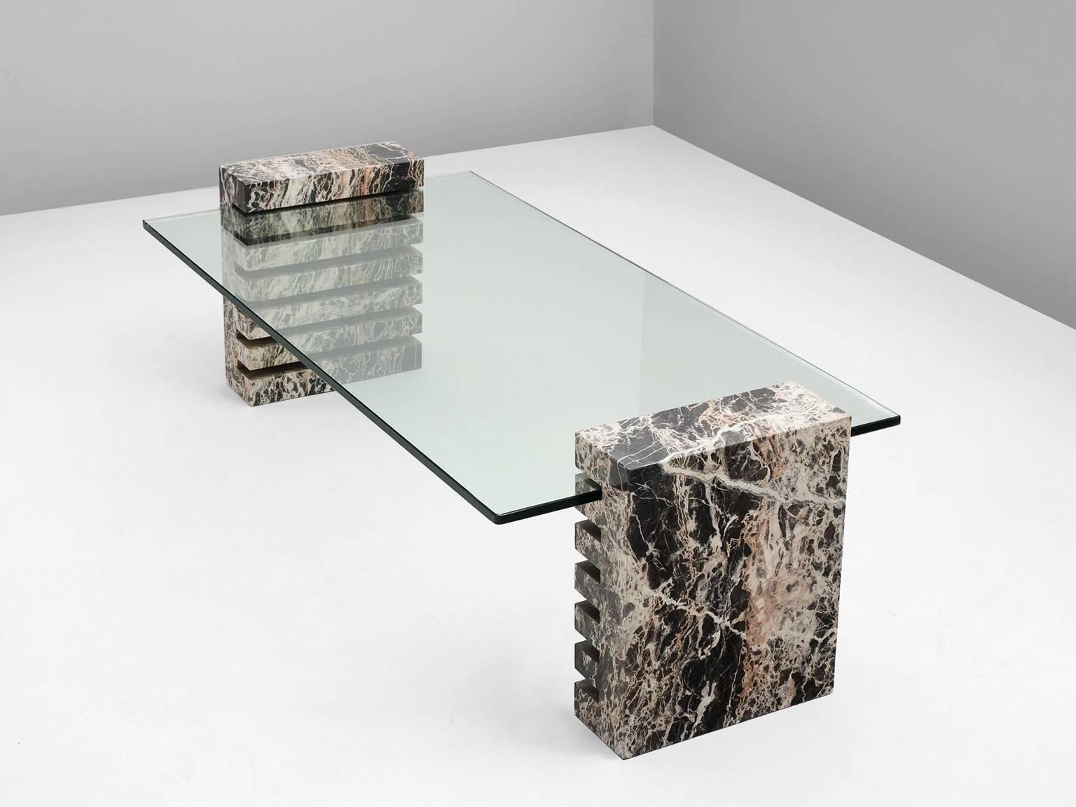 Coffee table, in marble and glass, European 1970s.

Cocktail table with rectangular top of clear glass. Two column base of multicolored marble. The base has several incisions for the glass top, which is adjustable in height. Due the clear glass