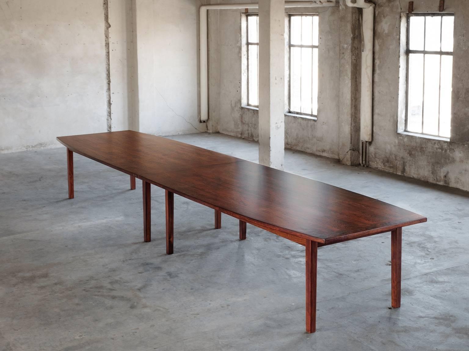 Large conference table, in rosewood, Scandinavia, 1960s.

Extremely large dining table of five meters, consist of two pieces. Combined the parts have a slightly curved boat shaped top, accomplished by eight cubic legs. Due the great size the grain