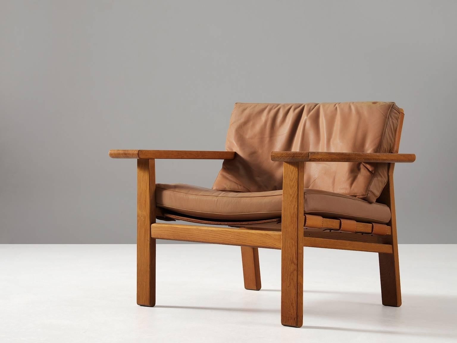 Armchair, in oak and leather, by Kurt Østervig for K.P. Møbler, Denmark, 1950s. 

Sturdy armchair in solid oak and saddle leather. This design of Ostervig has a strong resemblance to the Spanish Chair of Børge Mogensen. Yet the design of this