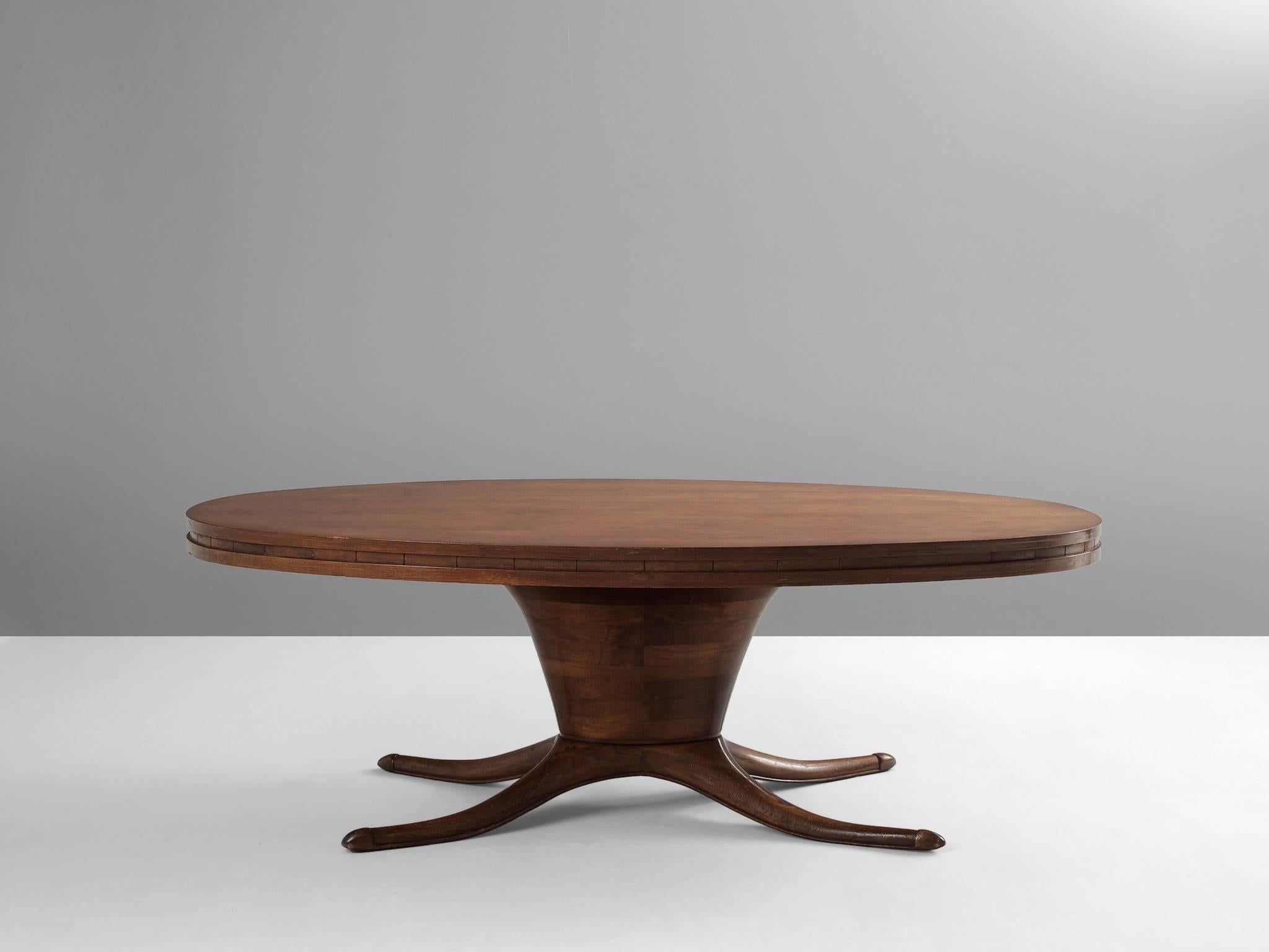 Dining table, in walnut, Italy 1950s.

Elegant oval dining table. The most striking detail of this table is the leg that is divided into four organic shaped feet. This is combined with the oval base and oval top. The shape of the four legs is