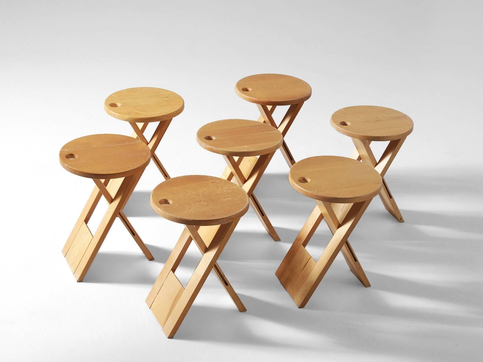 Set of four foldable stools in maple by Roger Tallon, France 1970s. 

Ingeniously designed retractable stools. Set of seven maple stools, which can easily be placed and fold up. The appearance of these round stool is simplistic, yet the design is